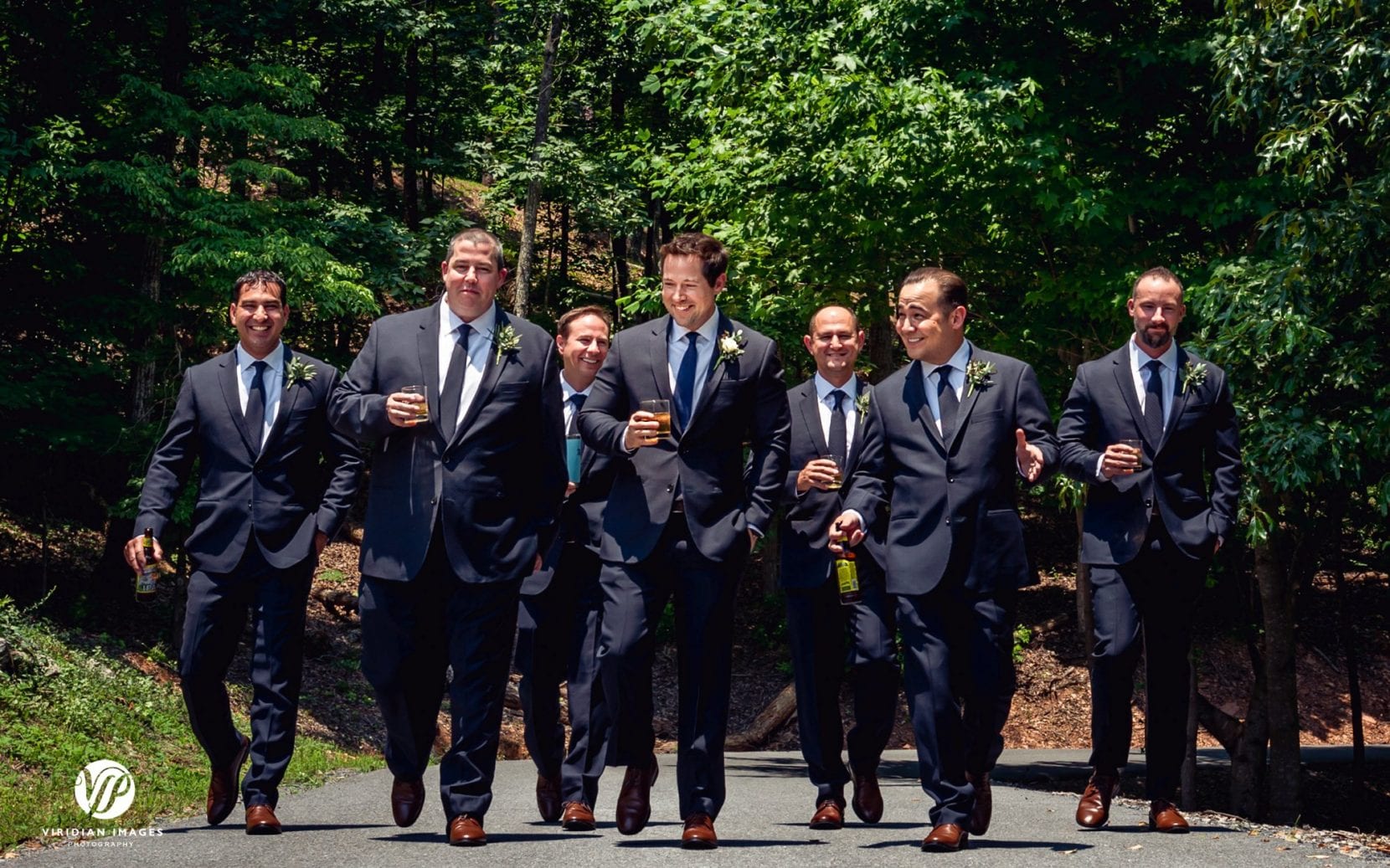 groomsmen having drinks while walking to wedding