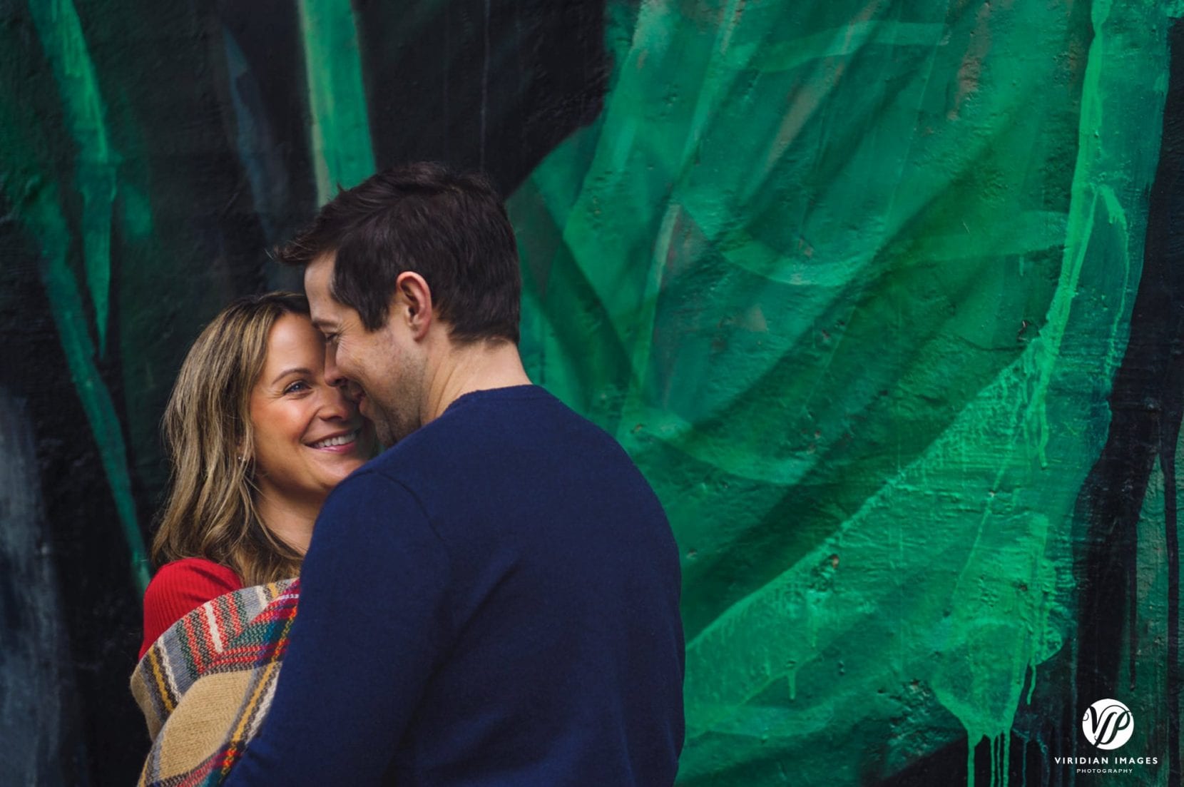 couple embrace front of mural at piedmont park