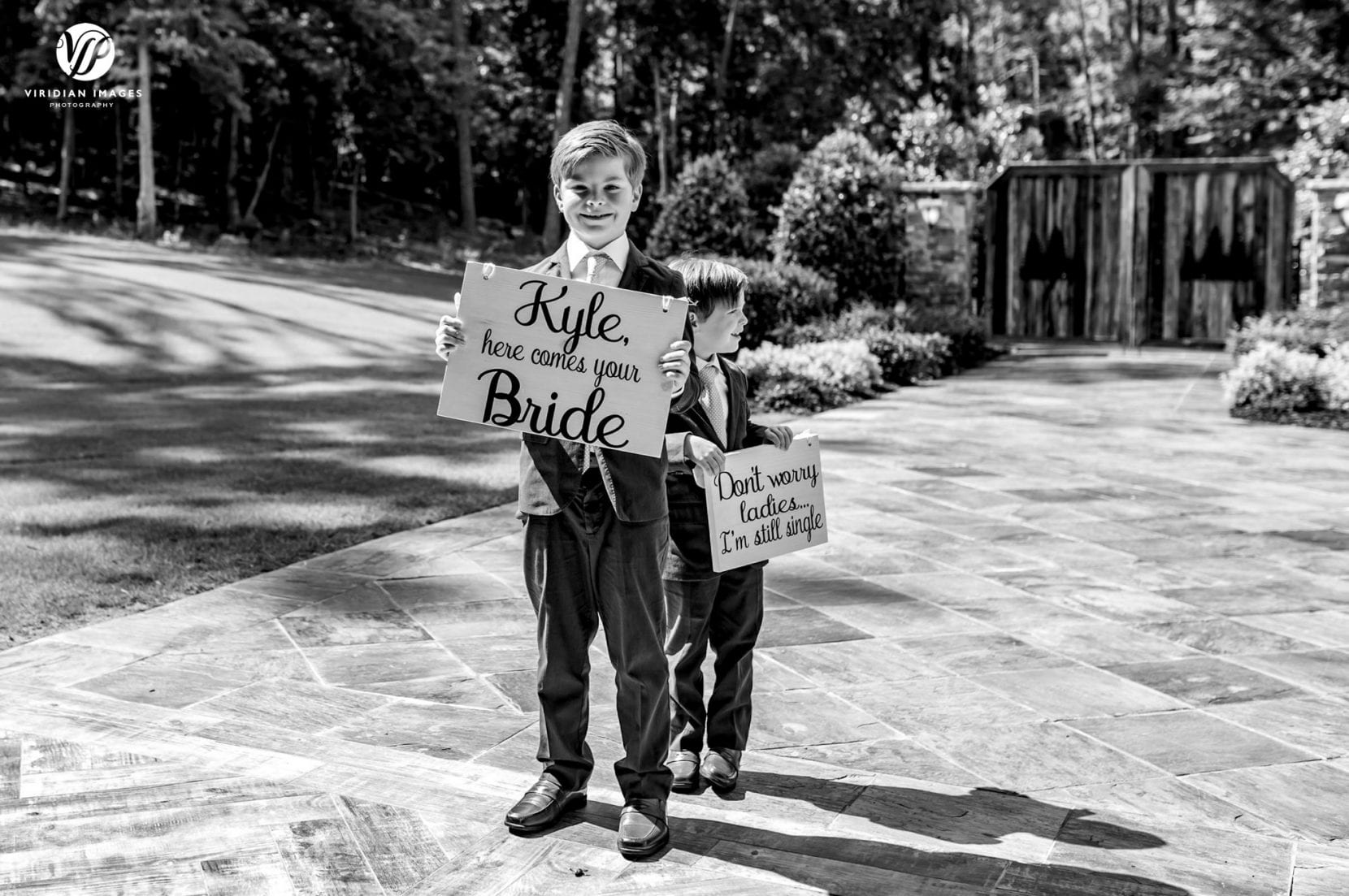 cute ring bearers ready with cute signs for groom about bride