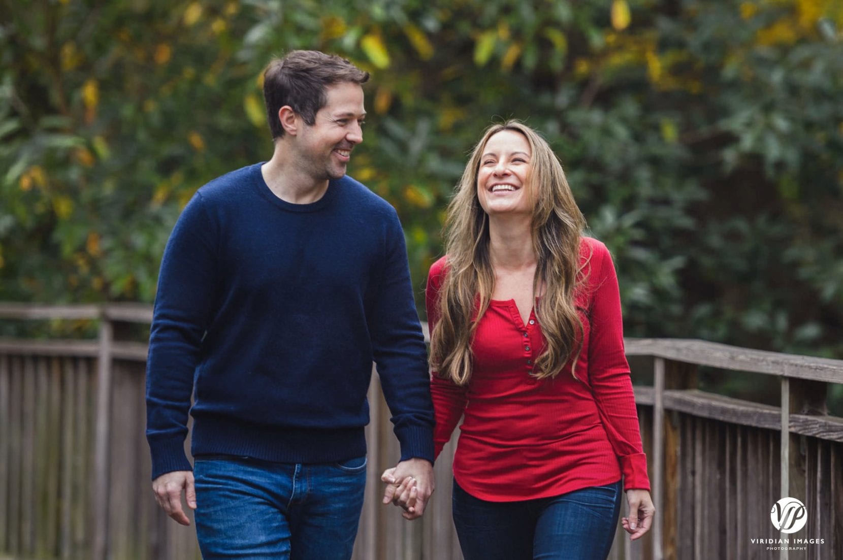 couple walking and laughing along boardwalk at piedmont park engagement photo