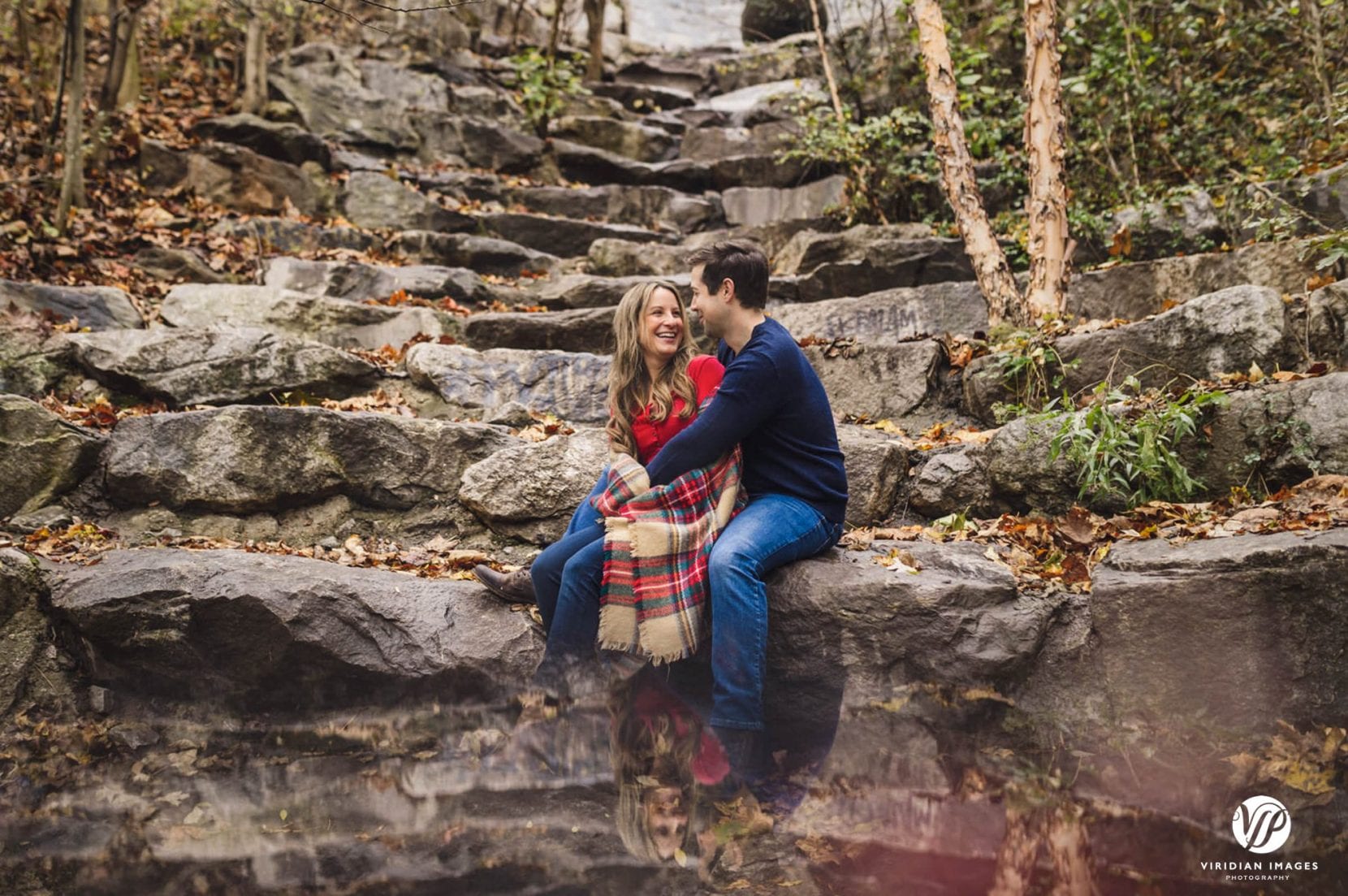 couple sit on rocks at piedmont park engagement photos