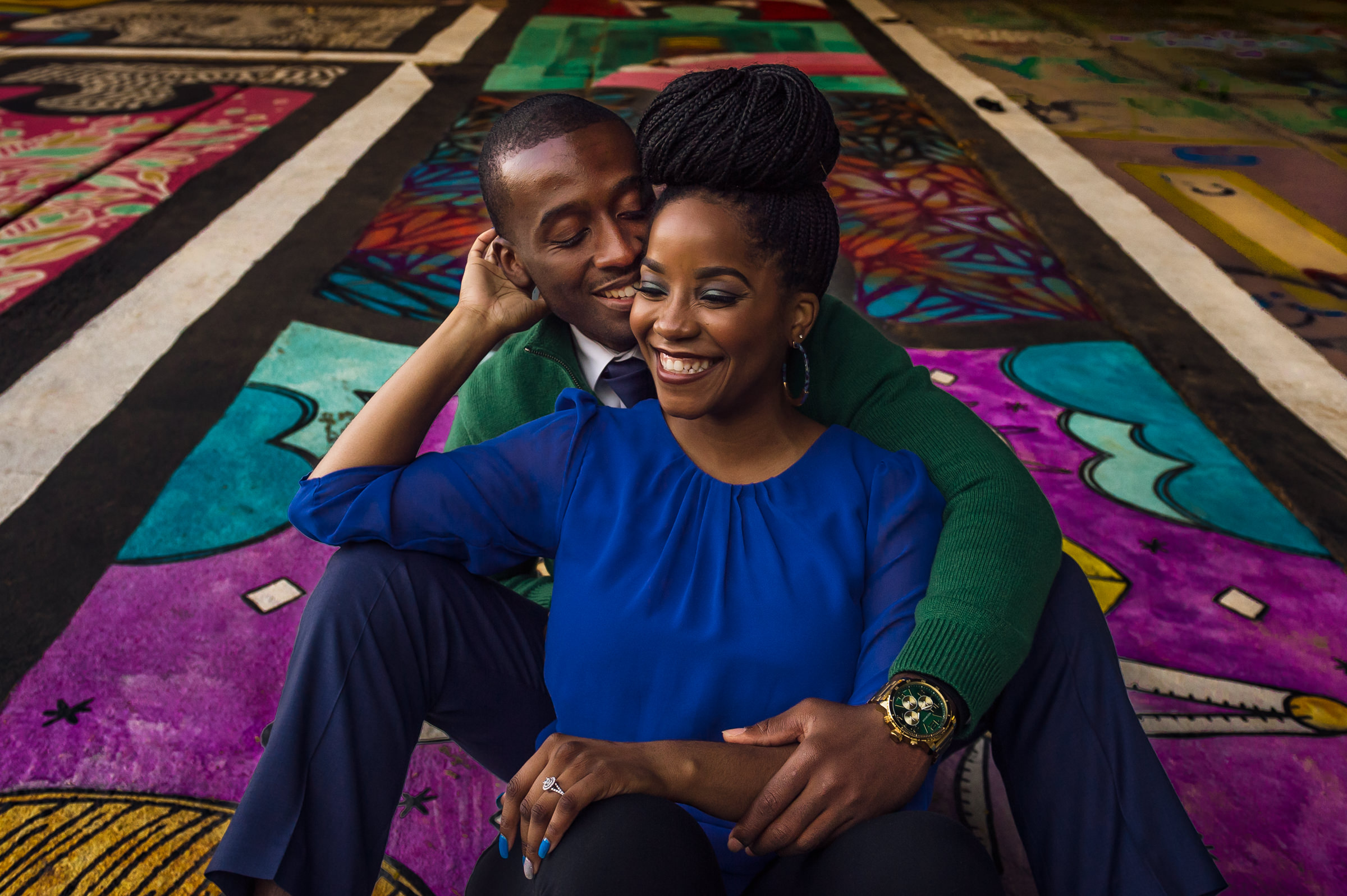 Engaged couple hug against graffiti at Atlanta Beltline