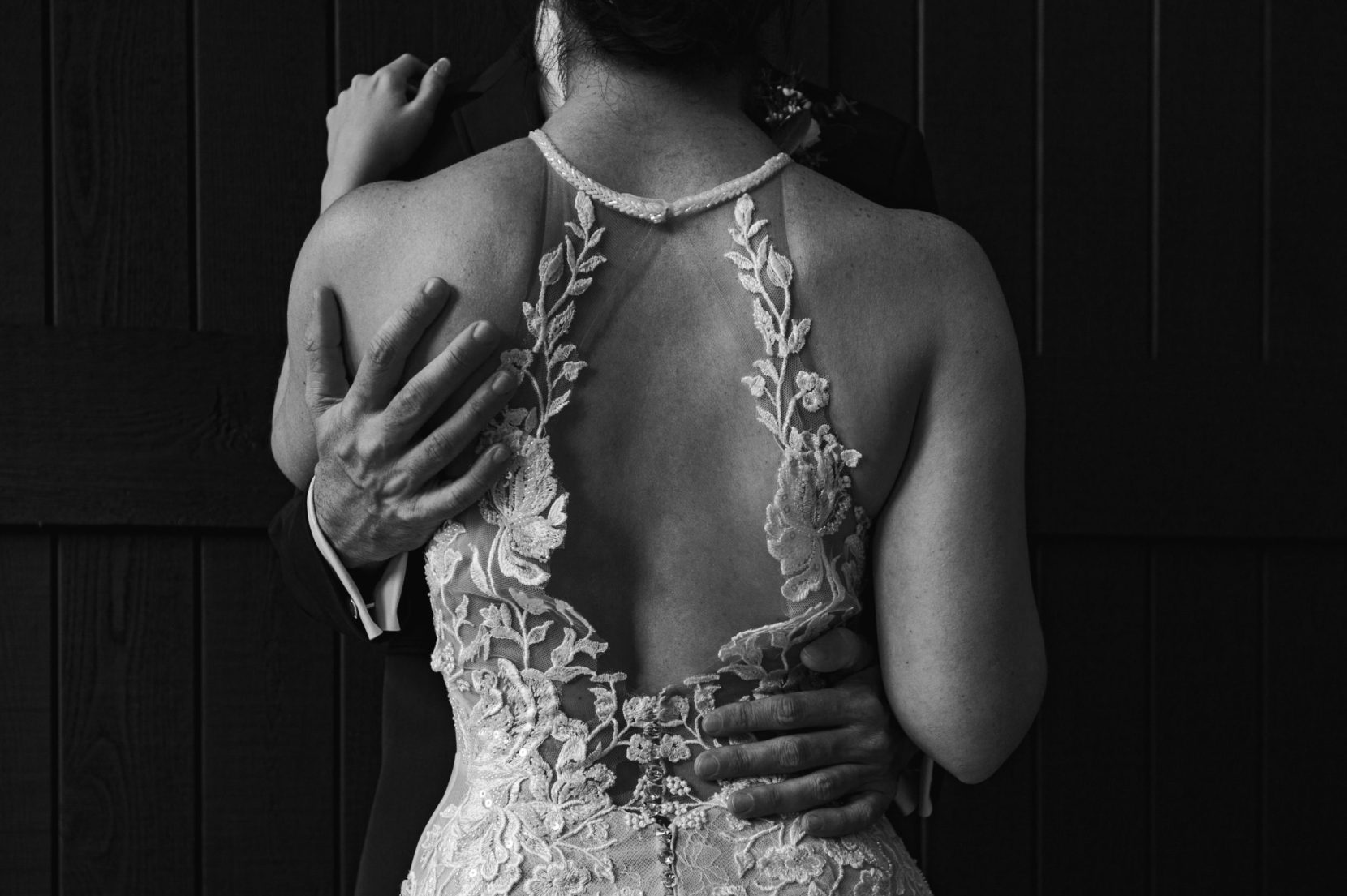 wedding dress lace detail grooms hands portrait black and white