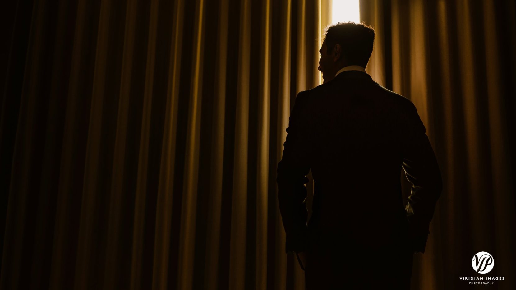 groom portrait yellow curtain drapes