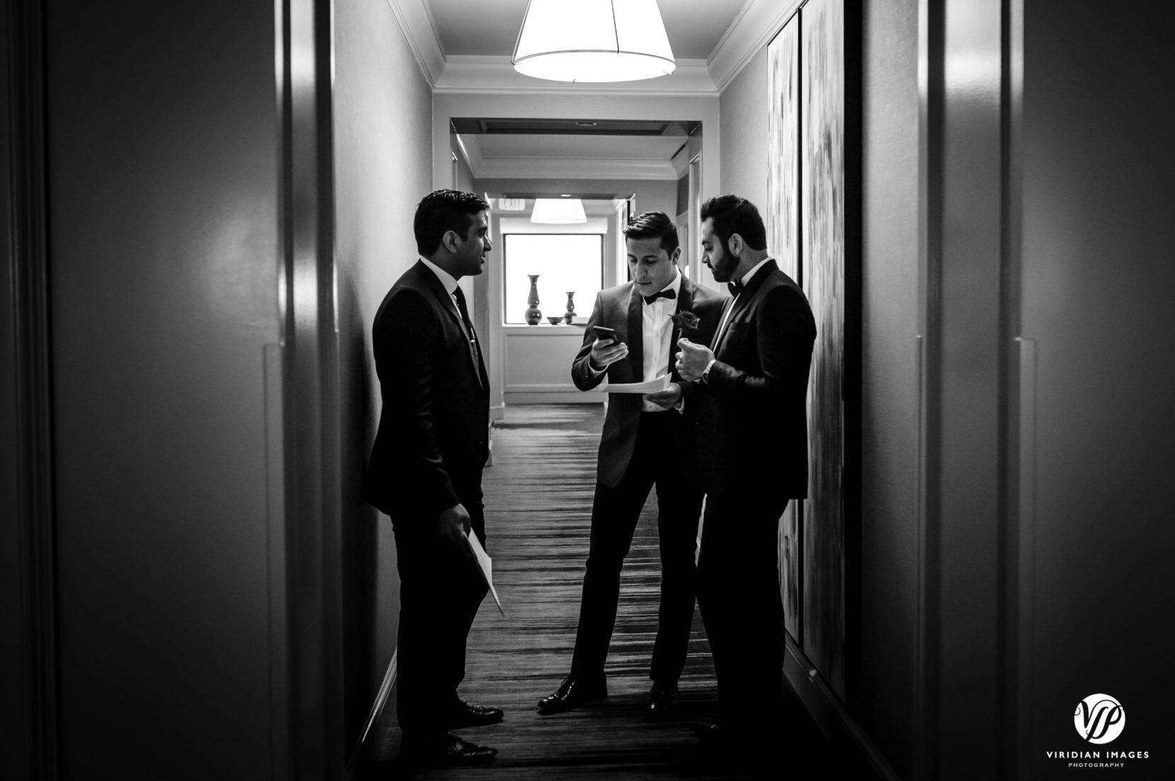 groomsmen hotel hallway reviewing toast notes