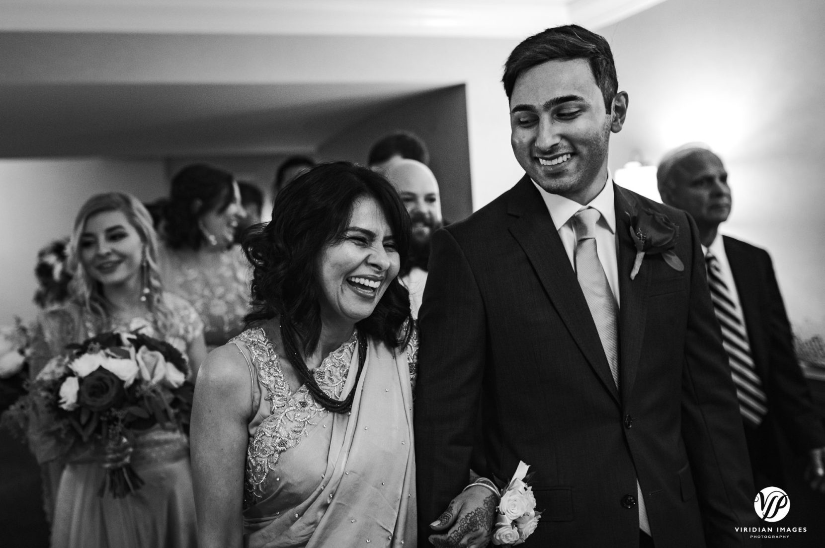 mom and groom sharing laugh before processional