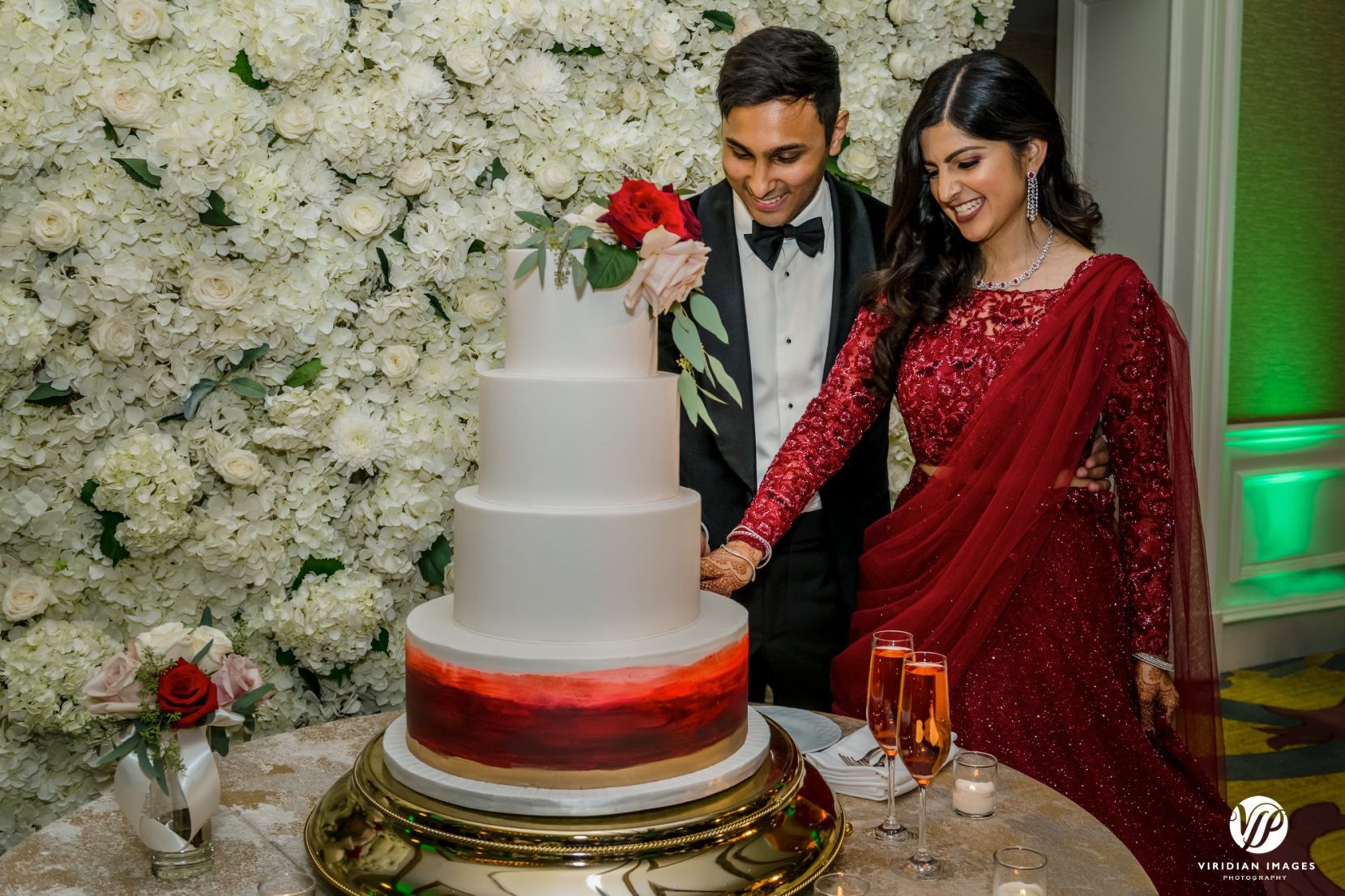 bride and groom cake cutting white flower wall