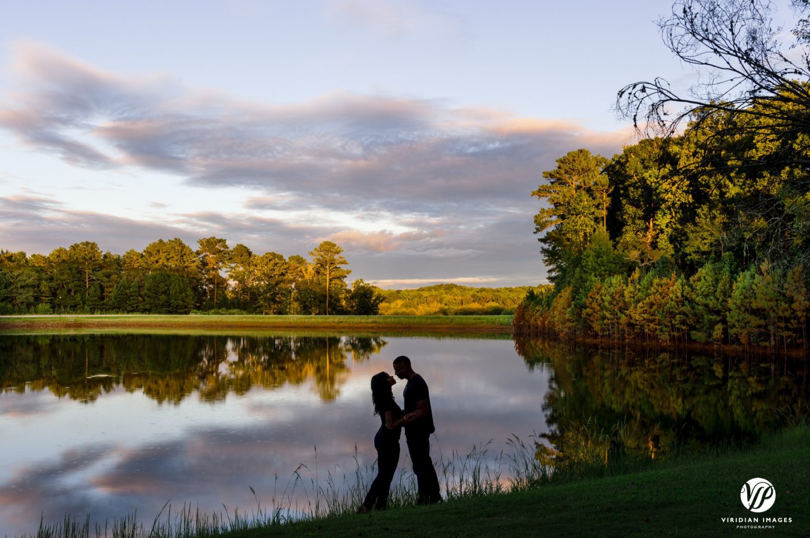 silhouette of couple against mirror like lake at sunset at foxhall