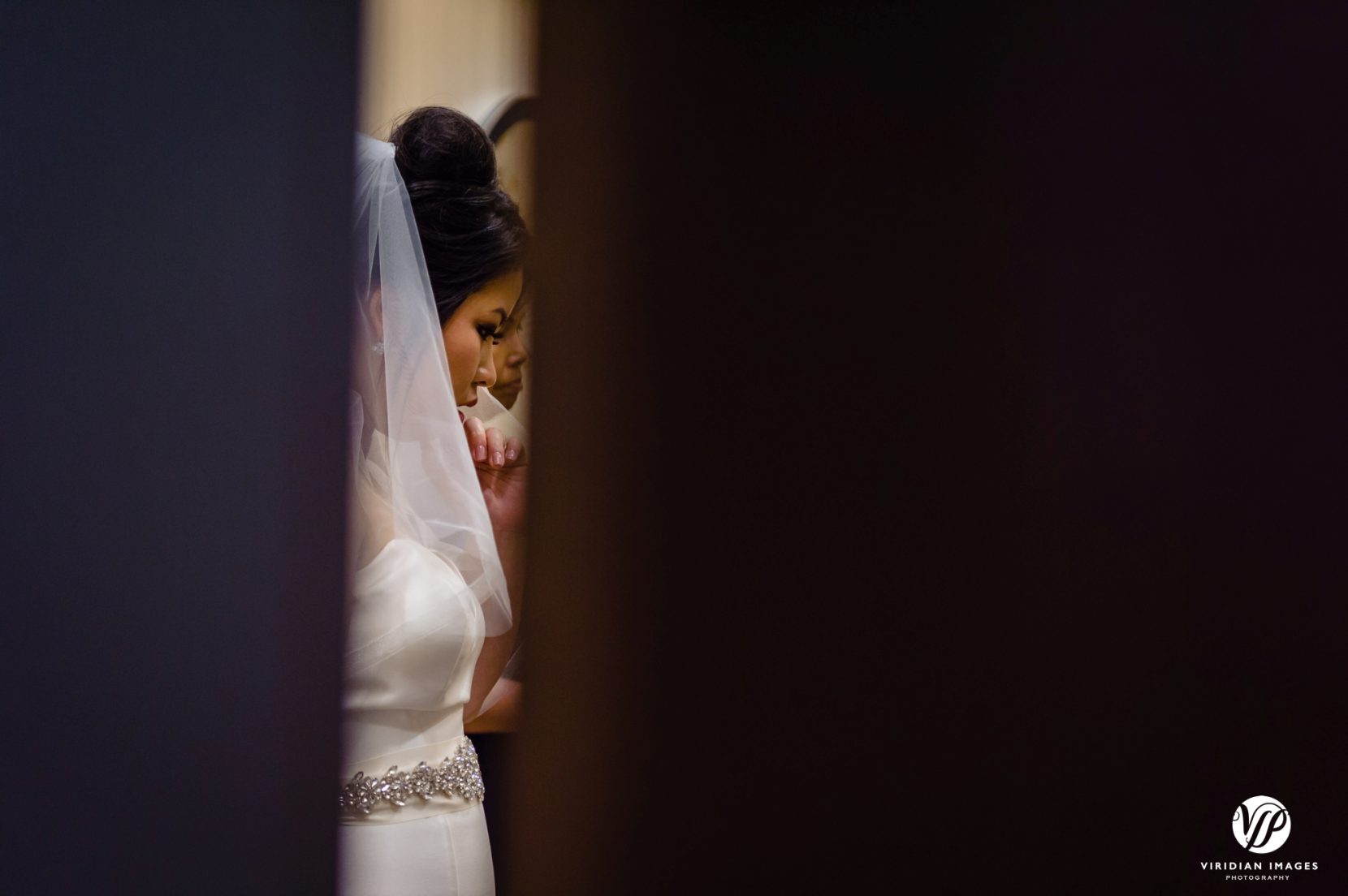 bride through crack of door getting ready before wedding