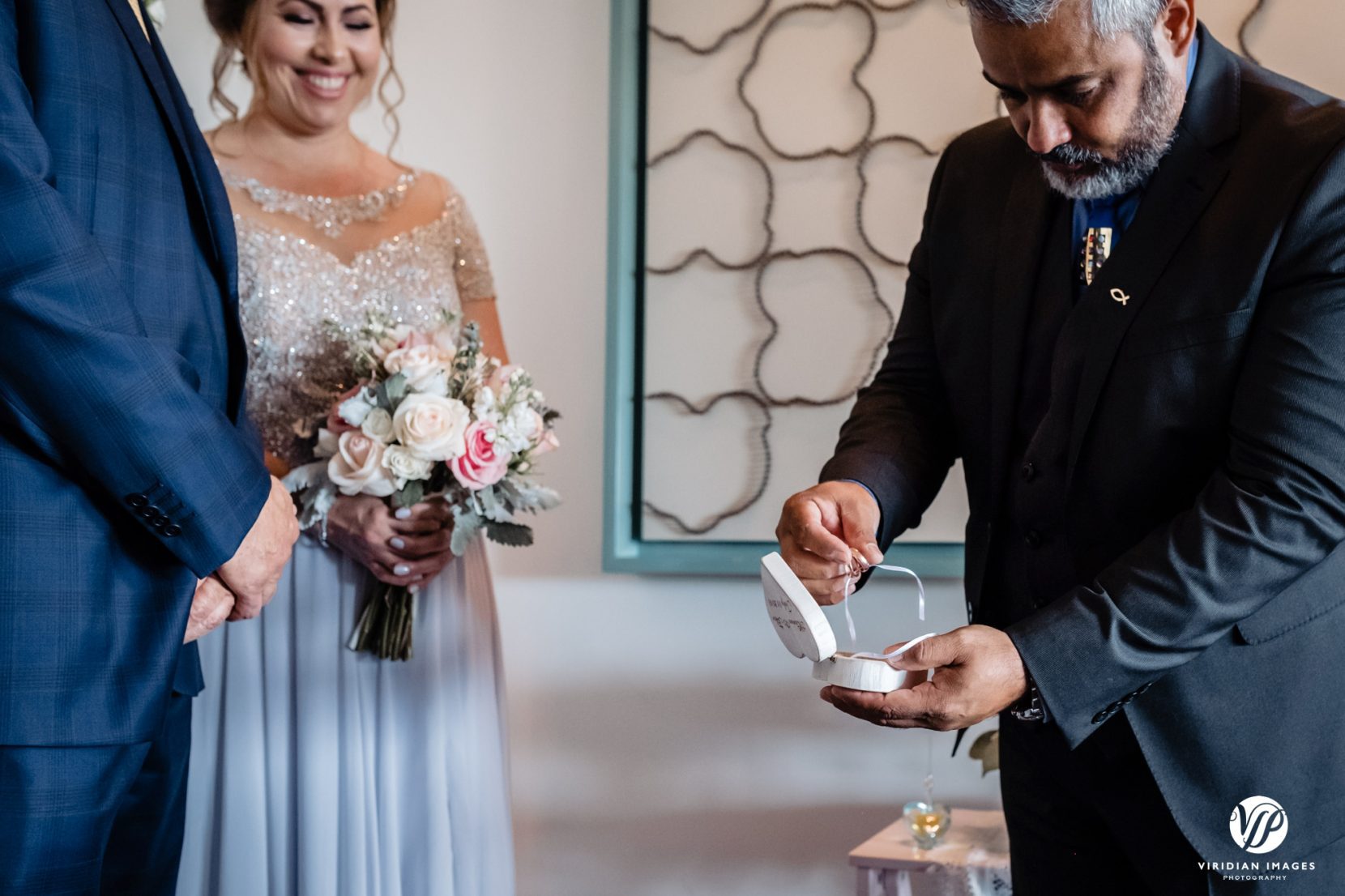 officiant holding wedding rings during ceremony