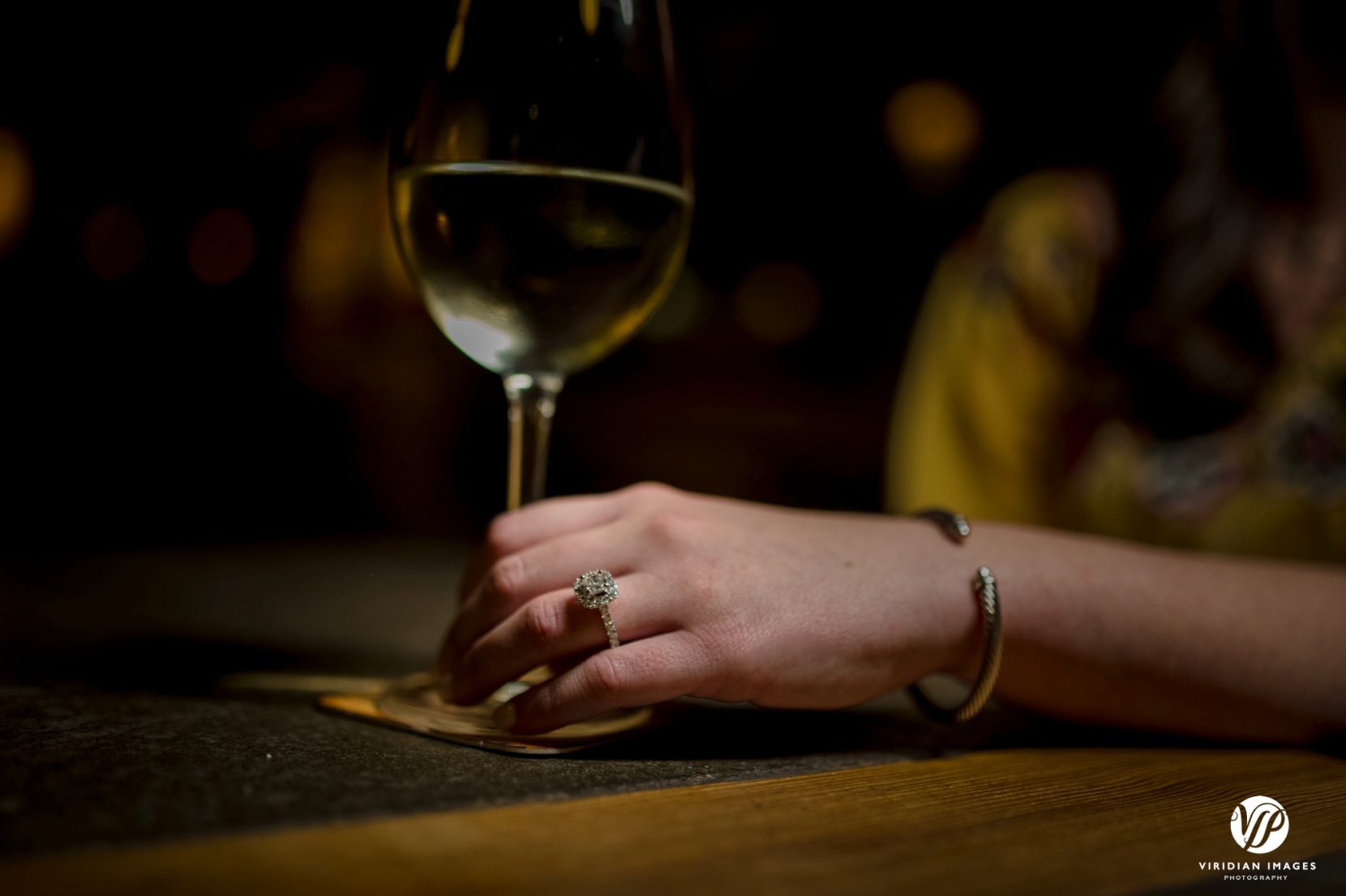 ring shot of girl holding glass of white wine