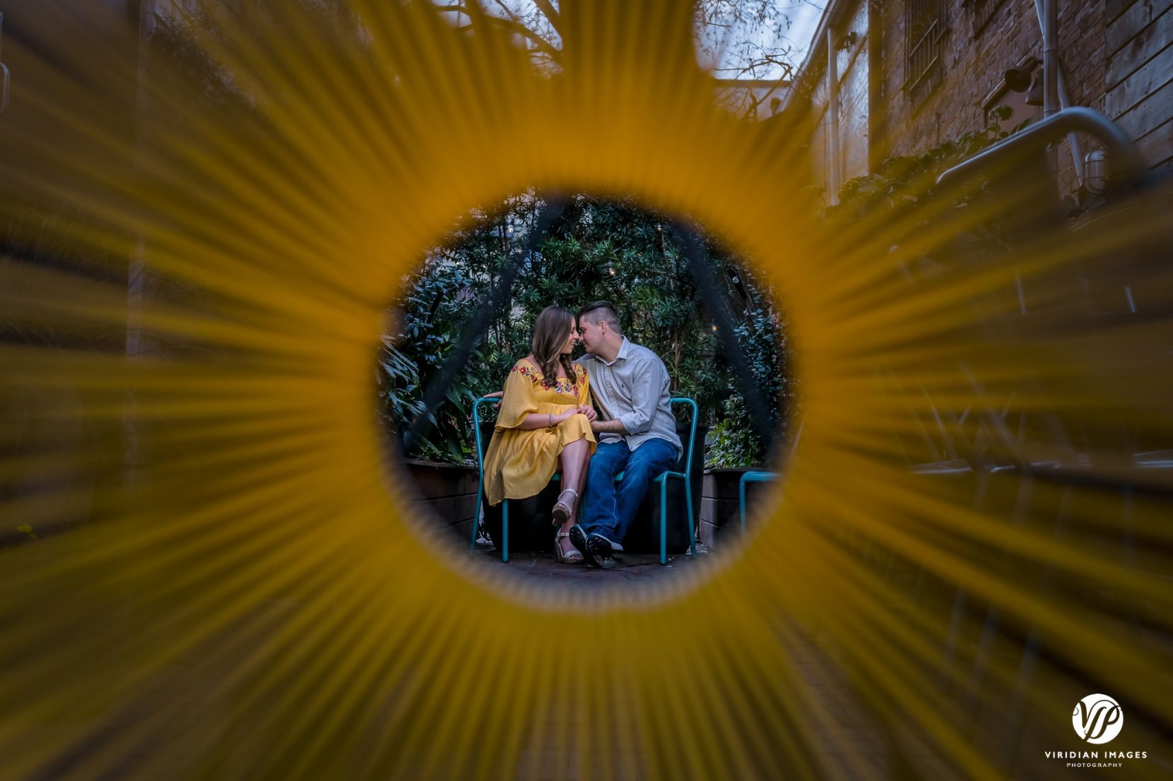 couple cuddle together photographed through chair decor
