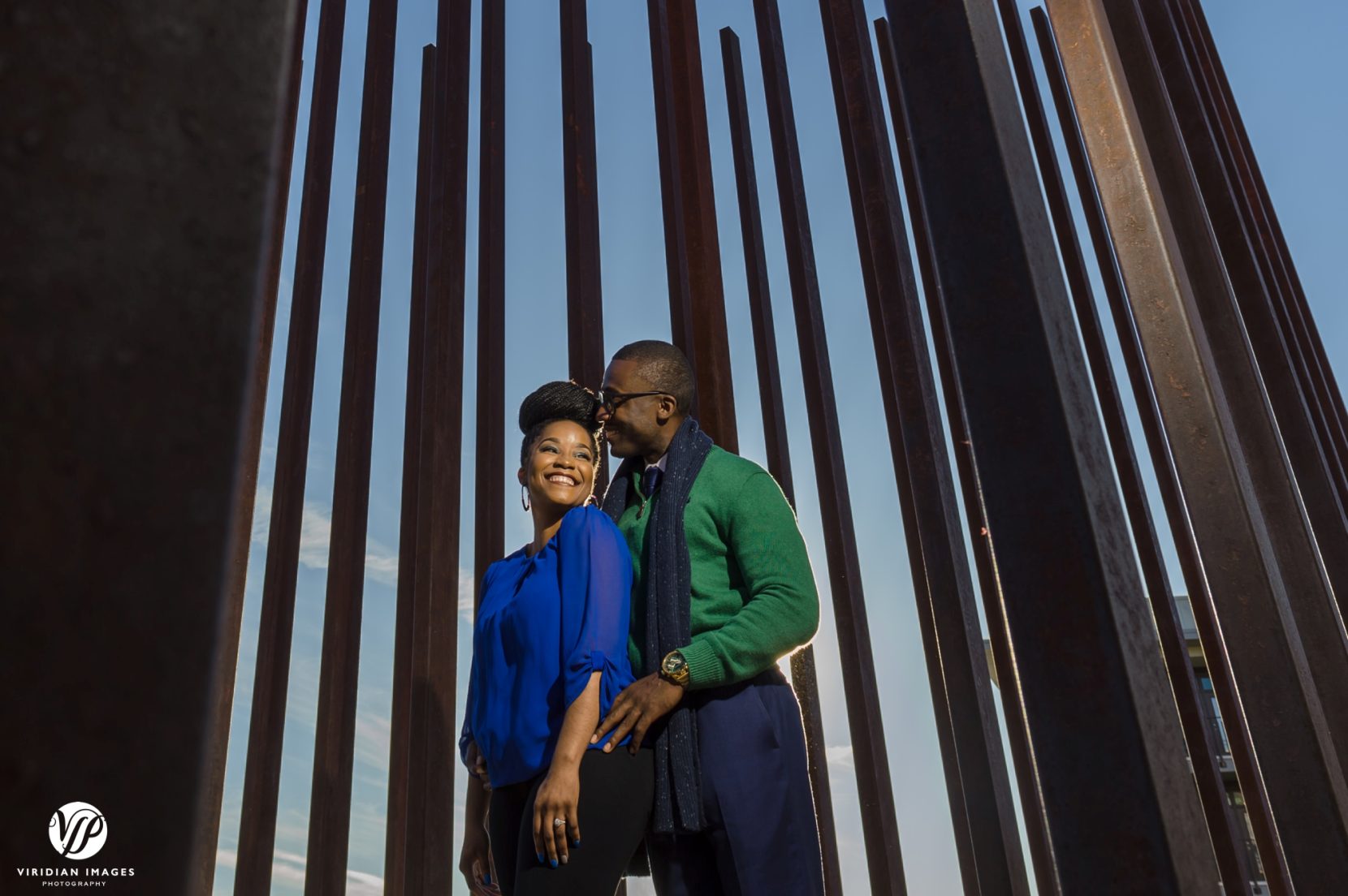 Stylish couple engagement photo against art installation and blue skies on Atlanta Beltline