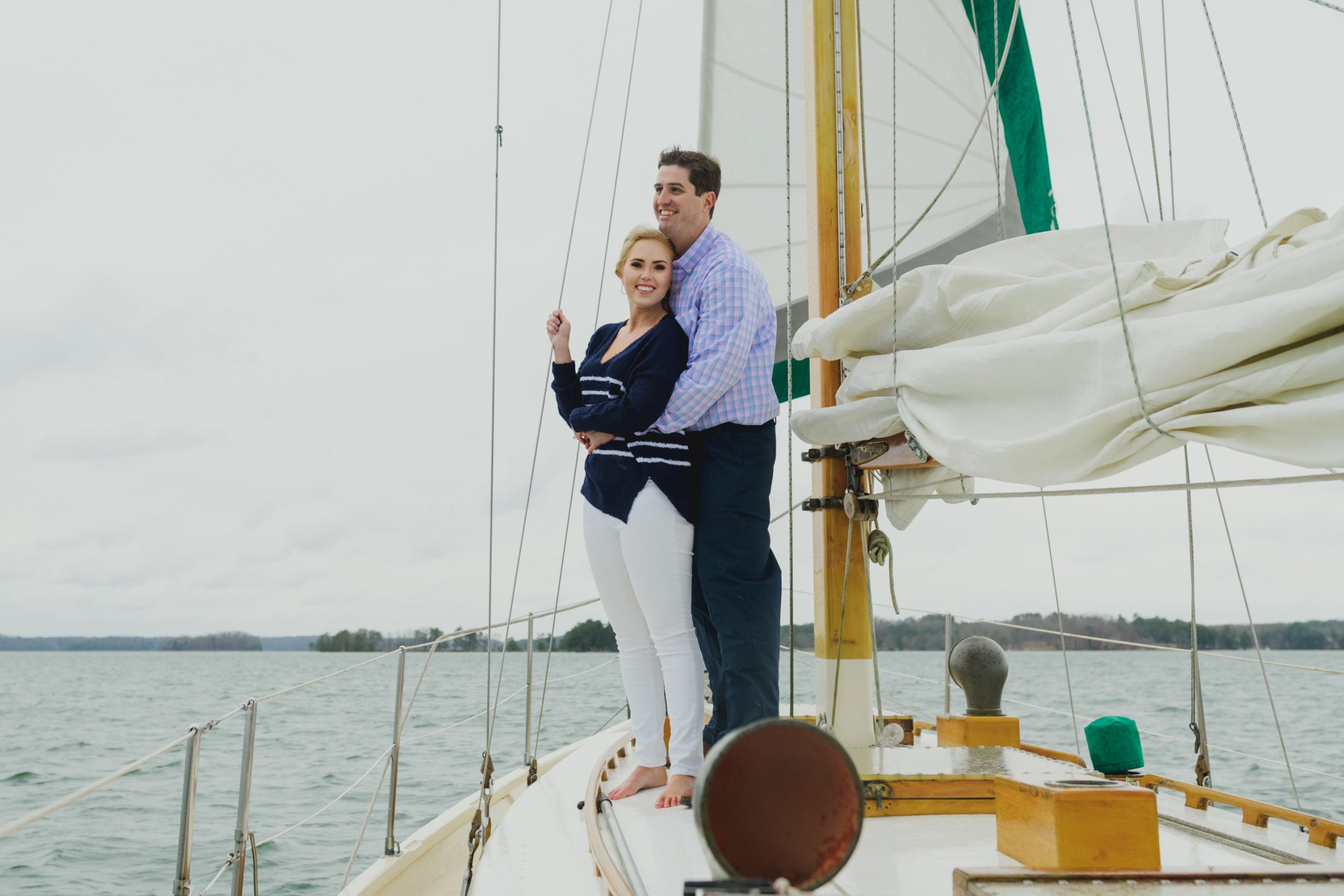 Couple staying warm on deck of sailboat