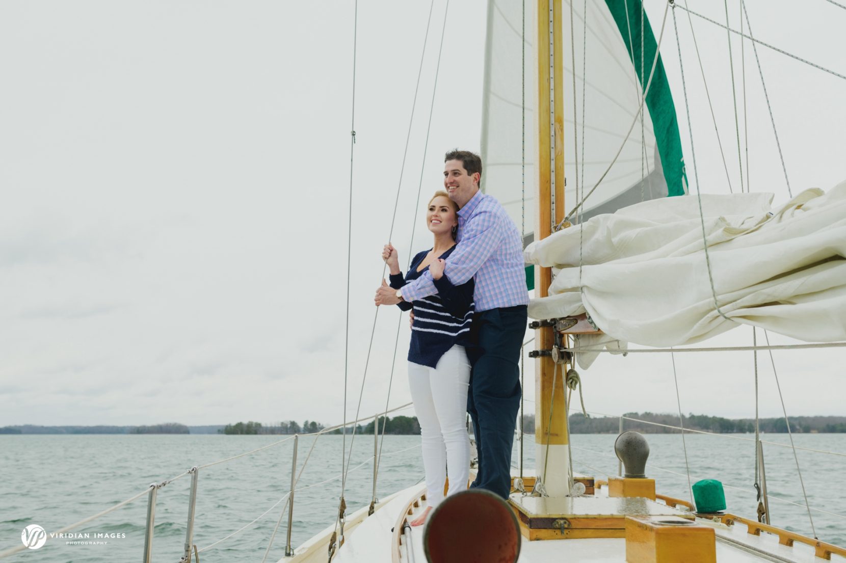 Couple snuggling on sailboat deck during winter on Lake Lanier