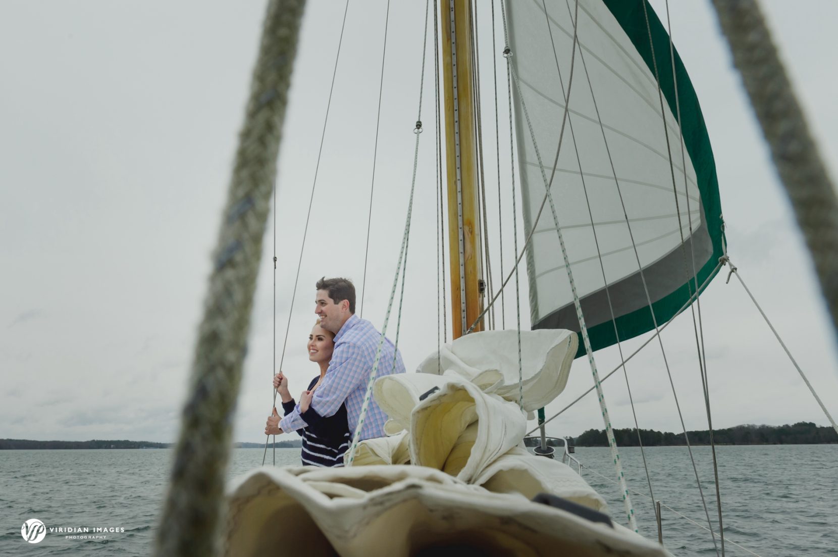 Couple keeping warm on deck of sailboat during photoshoot