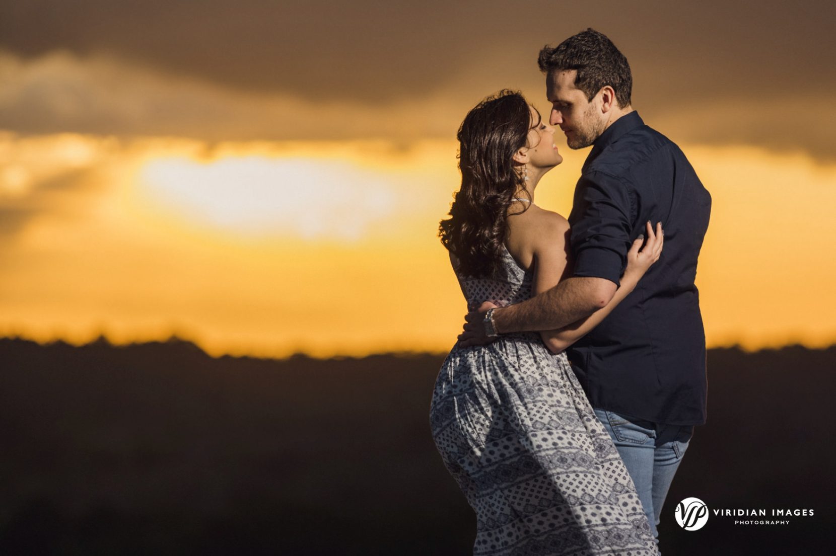 Intimate moment during spring engagement session during golden hour stormy skies on top of granite Mountain