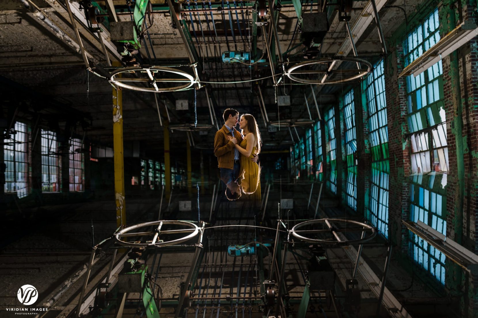 Creative reflection of couple in the middle of ruin factory floor in Lindale Mill