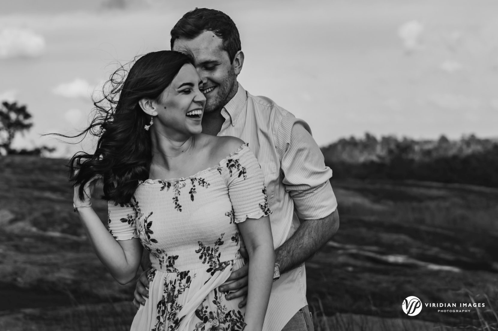 Fun loving moment of couple laughing during spring engagement shoot on top of Mountain