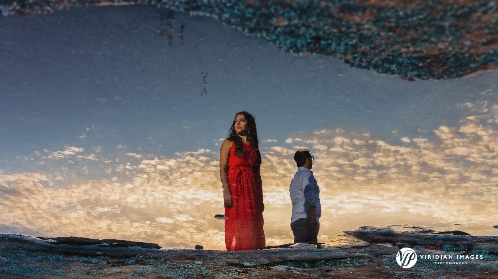 couple reflected on moving puddle during golden hour on arabia mountain