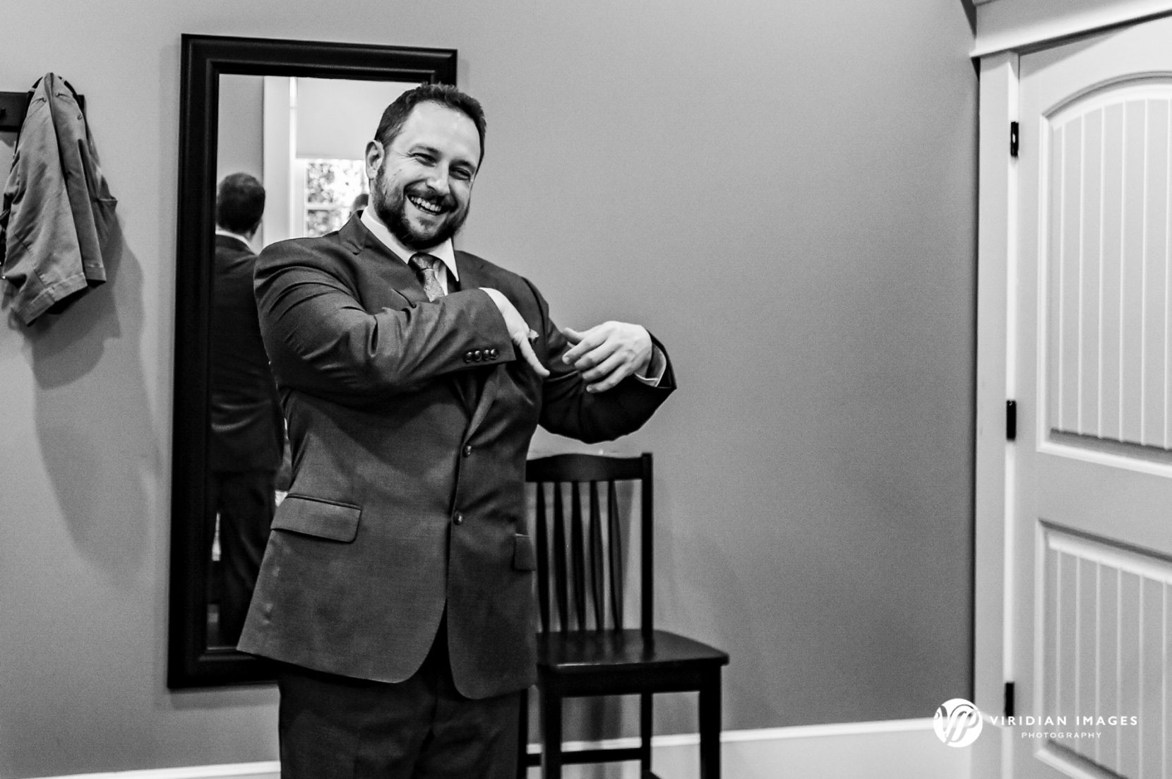 Groom putting pocket square into suit pocket while getting ready for wedding