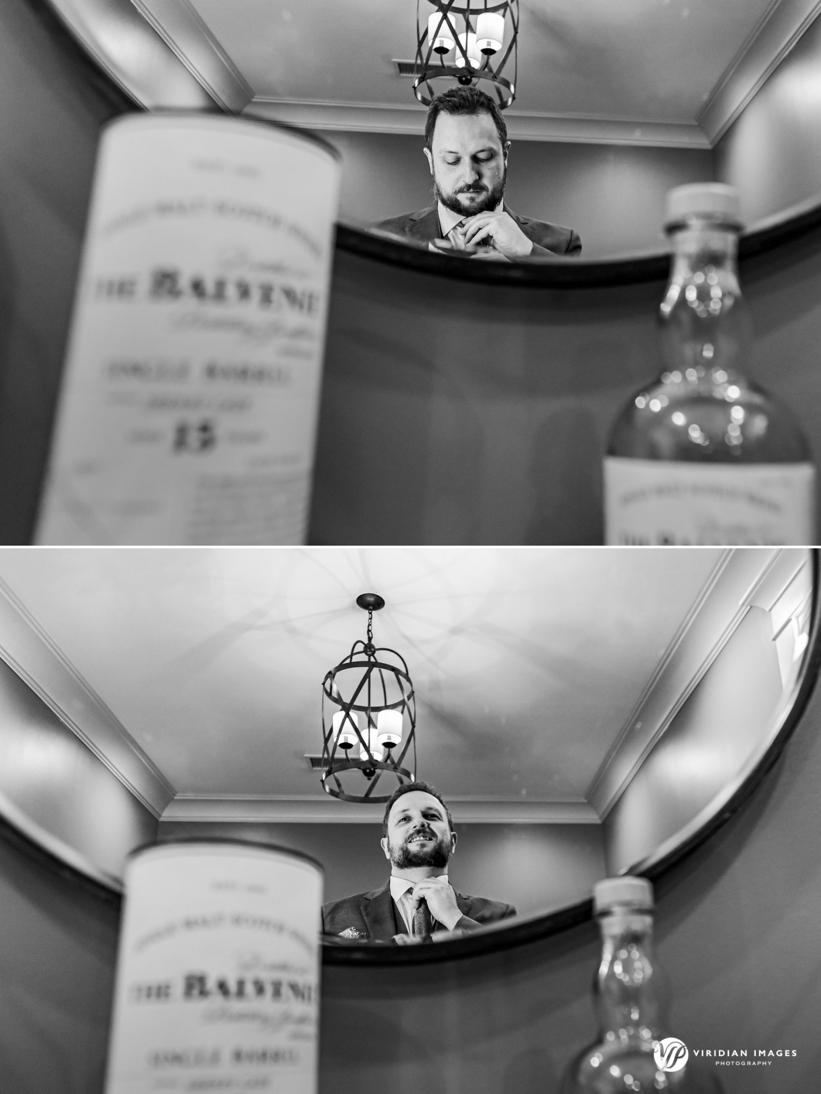 black and white photos of groom getting ready through mirror reflection bottle of whiskey on table