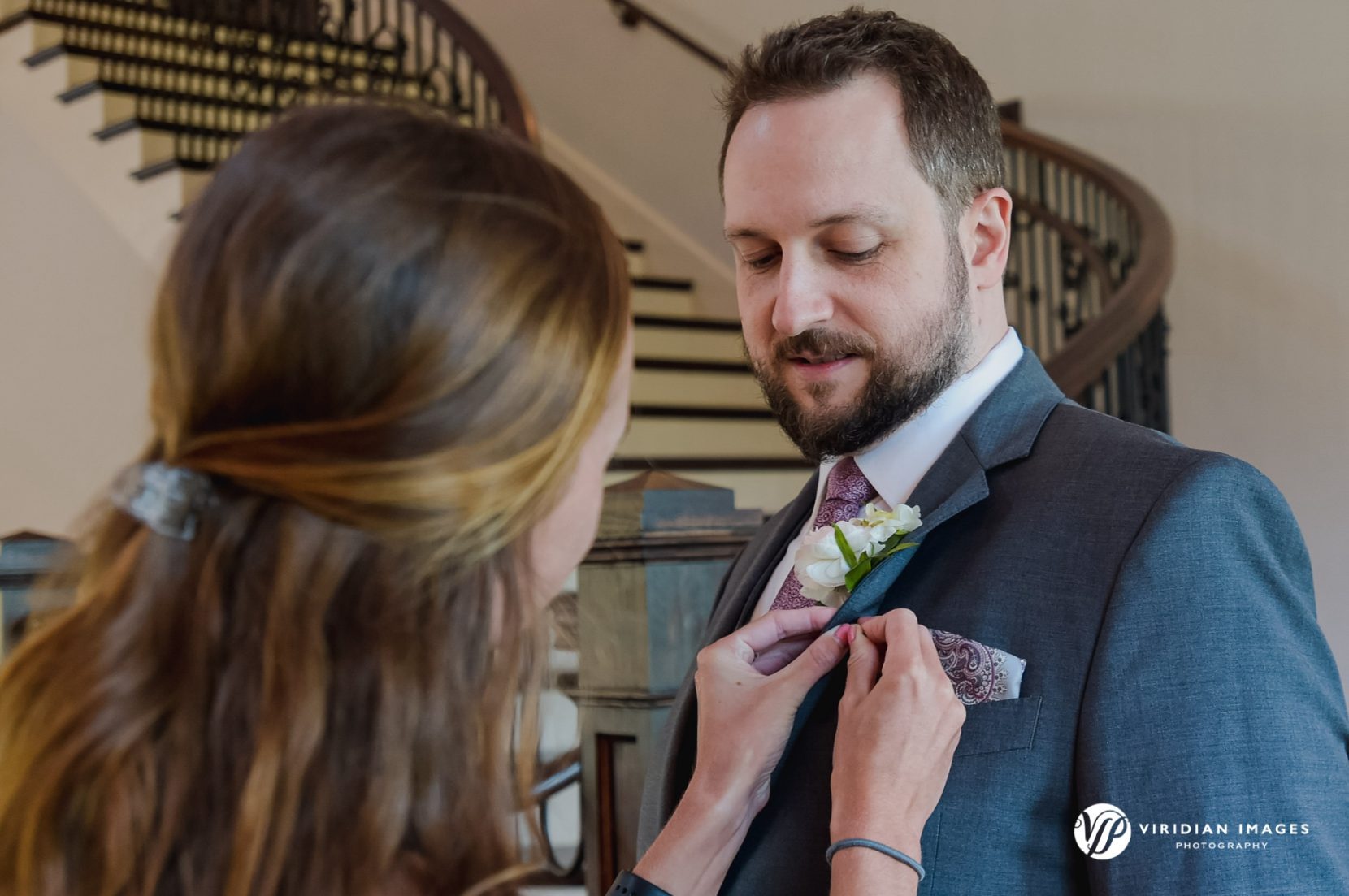 Planner pinning boutonniere on groom