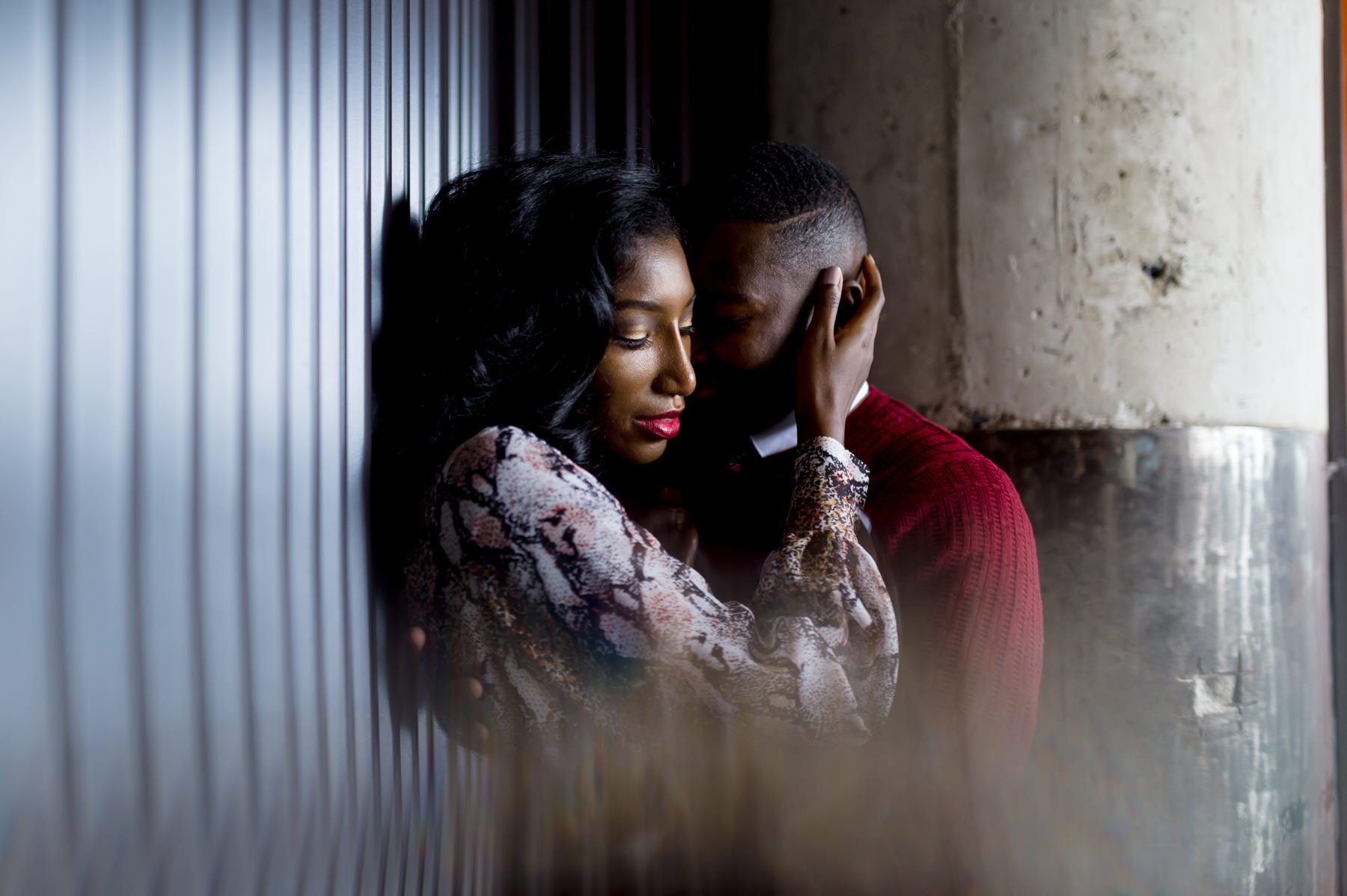 Engaged couple embracing against metal wall at Ponce City Market