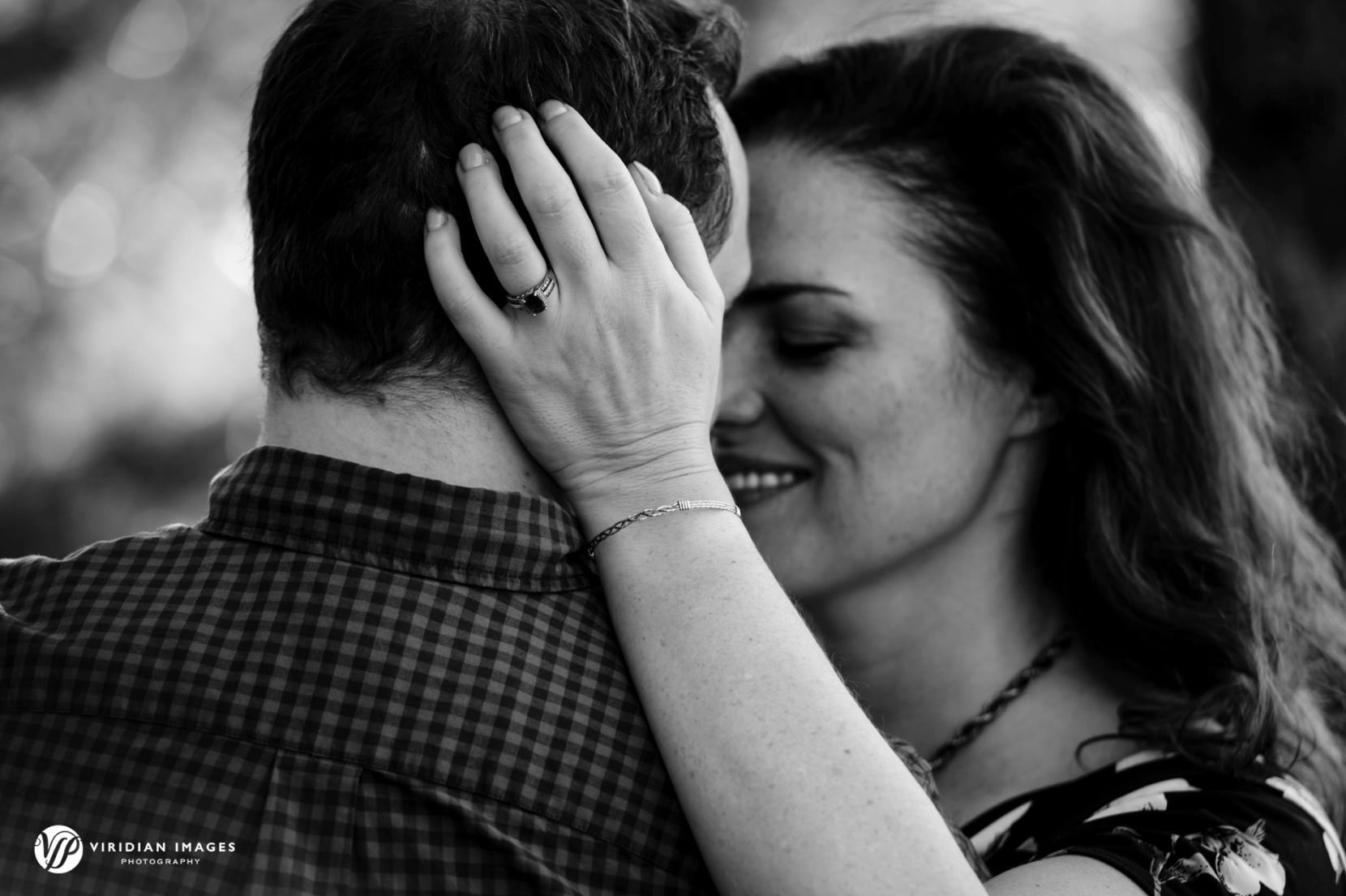 Engagement ring detail behind groom to be head