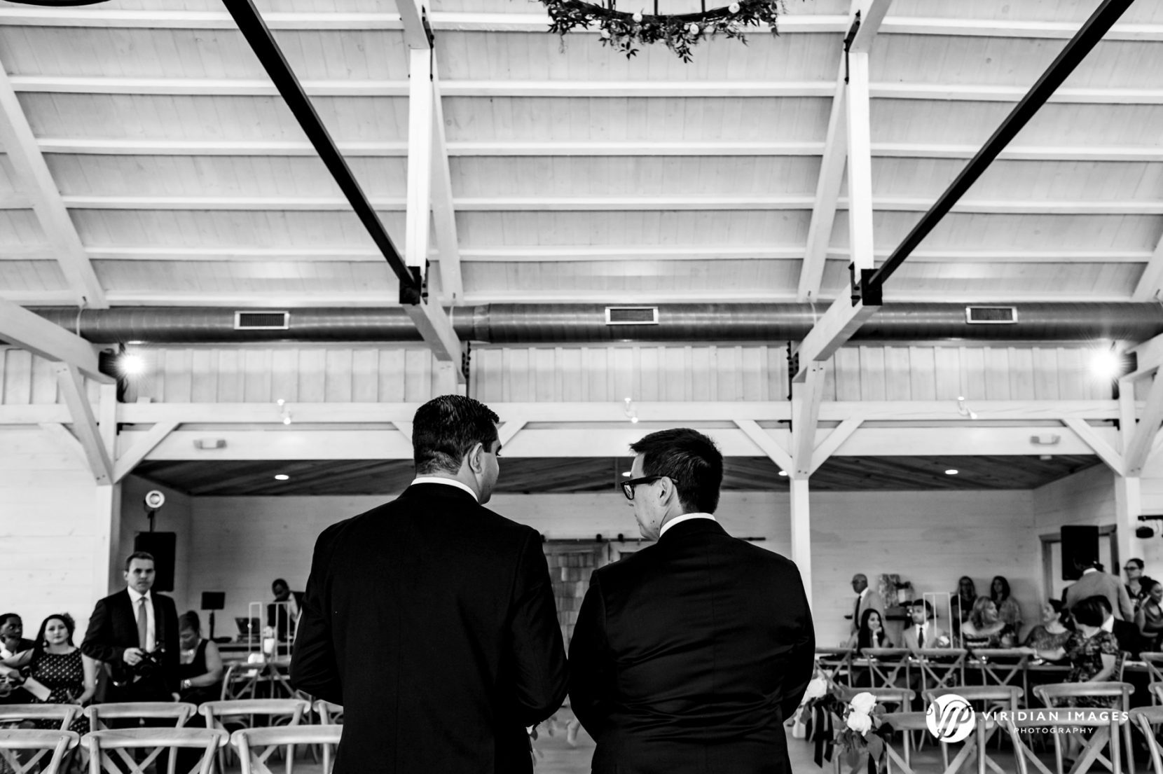 Groom at officiant from behind waiting for wedding processional 