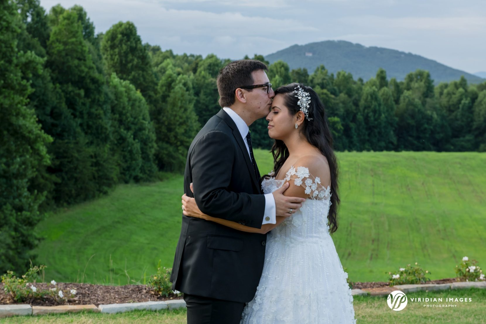 Naysha and Steven embrace with mountain views behind