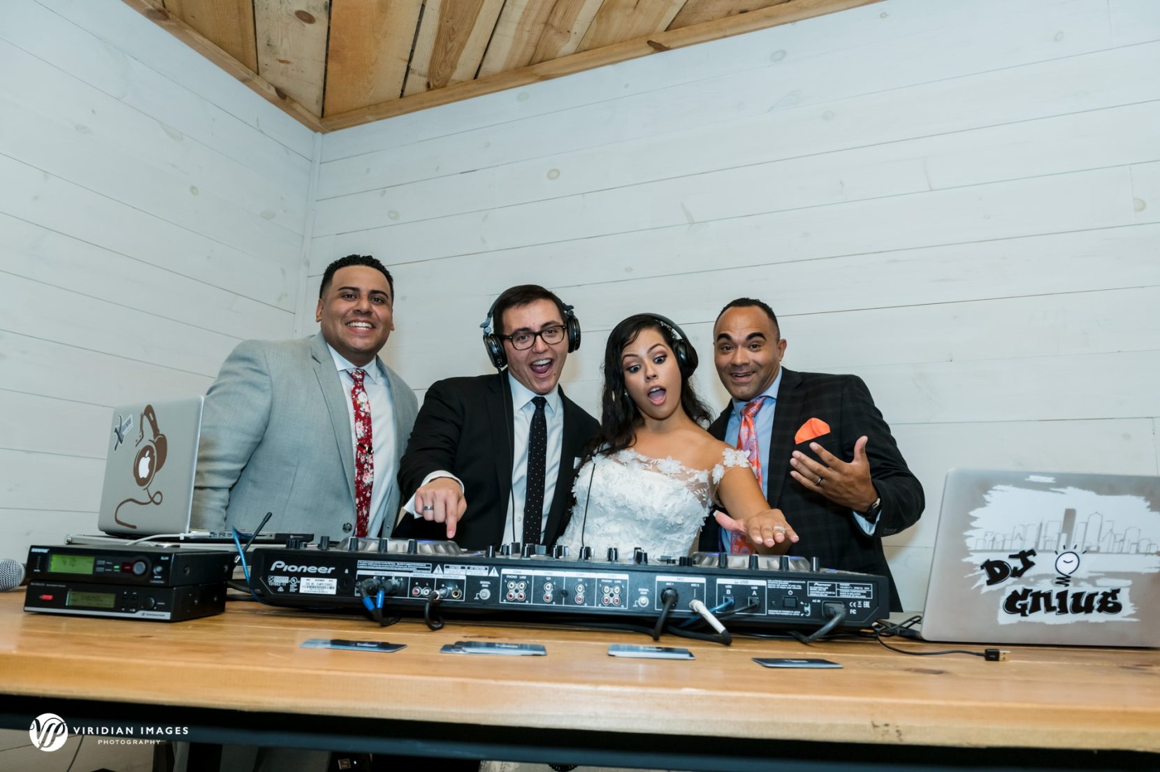 Bride and groom have fun with DJ scratching tunes during wedding reception