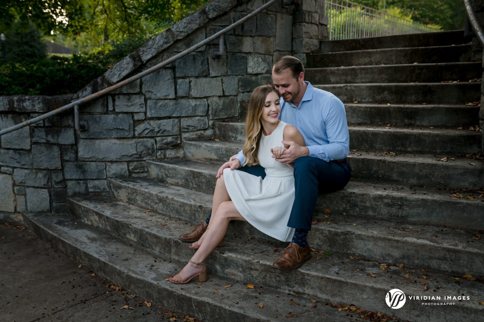 Engaged couple sitting during engagement session at Piedmont Park