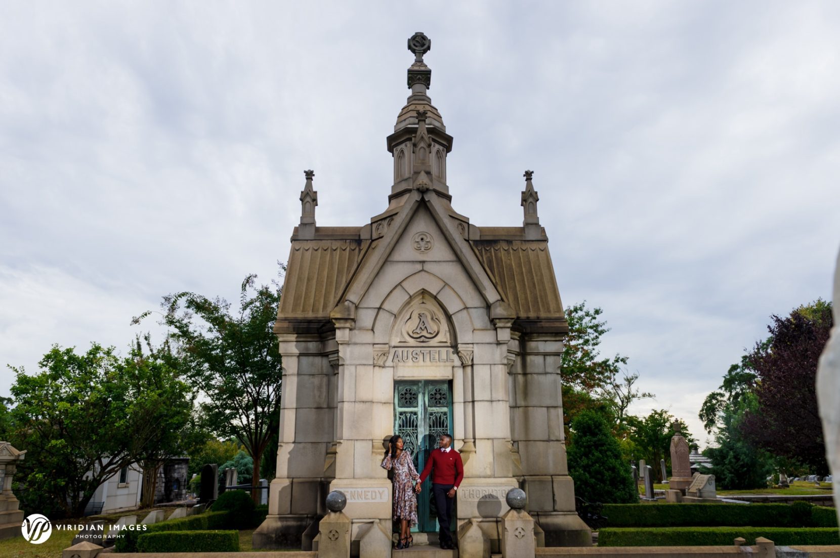 Editorial styled portrait of engaged couple in front of mausoleum at Oakland Cemetery