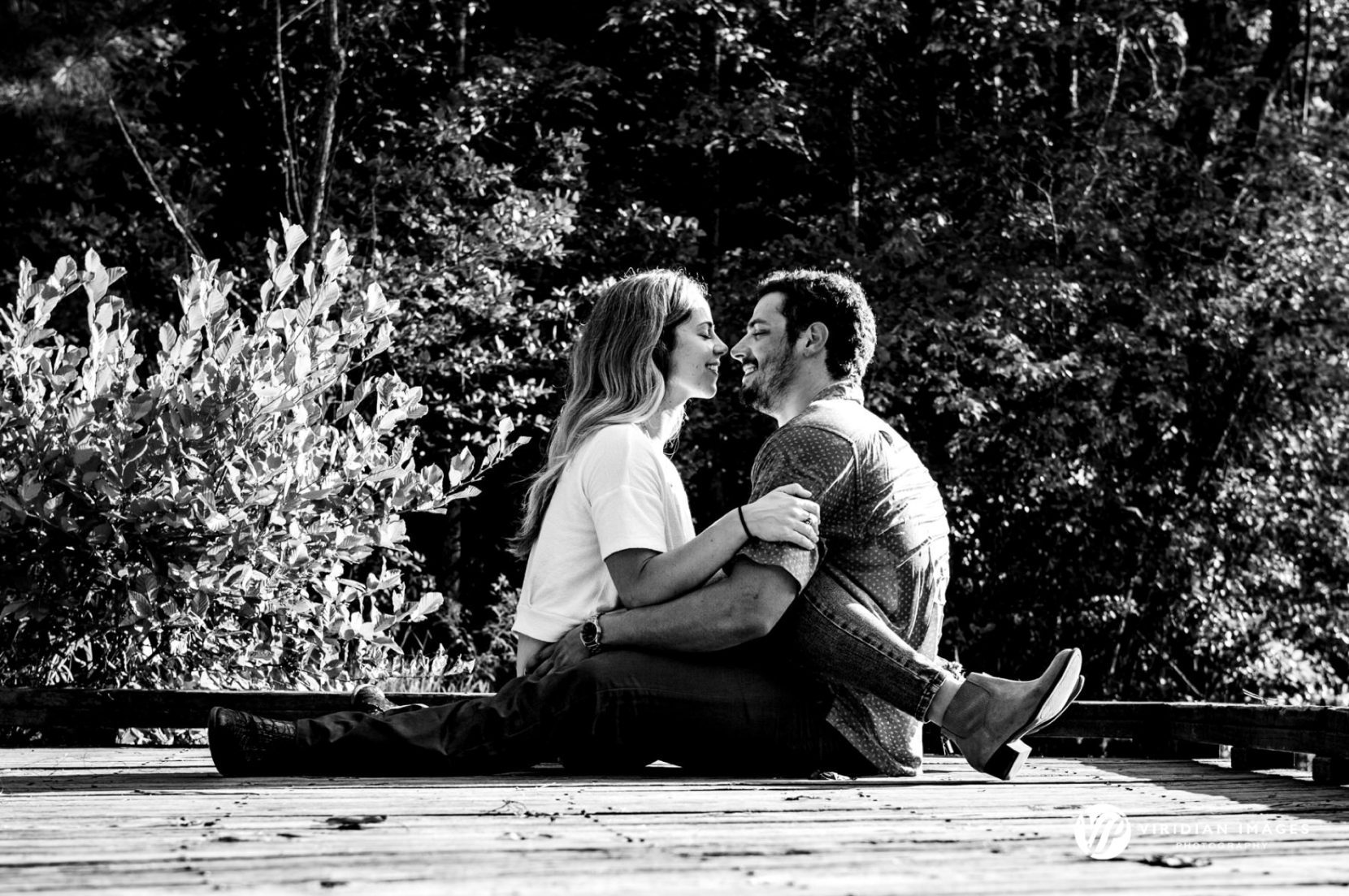 Couple sitting face to face on wooden deck at Sope Creek