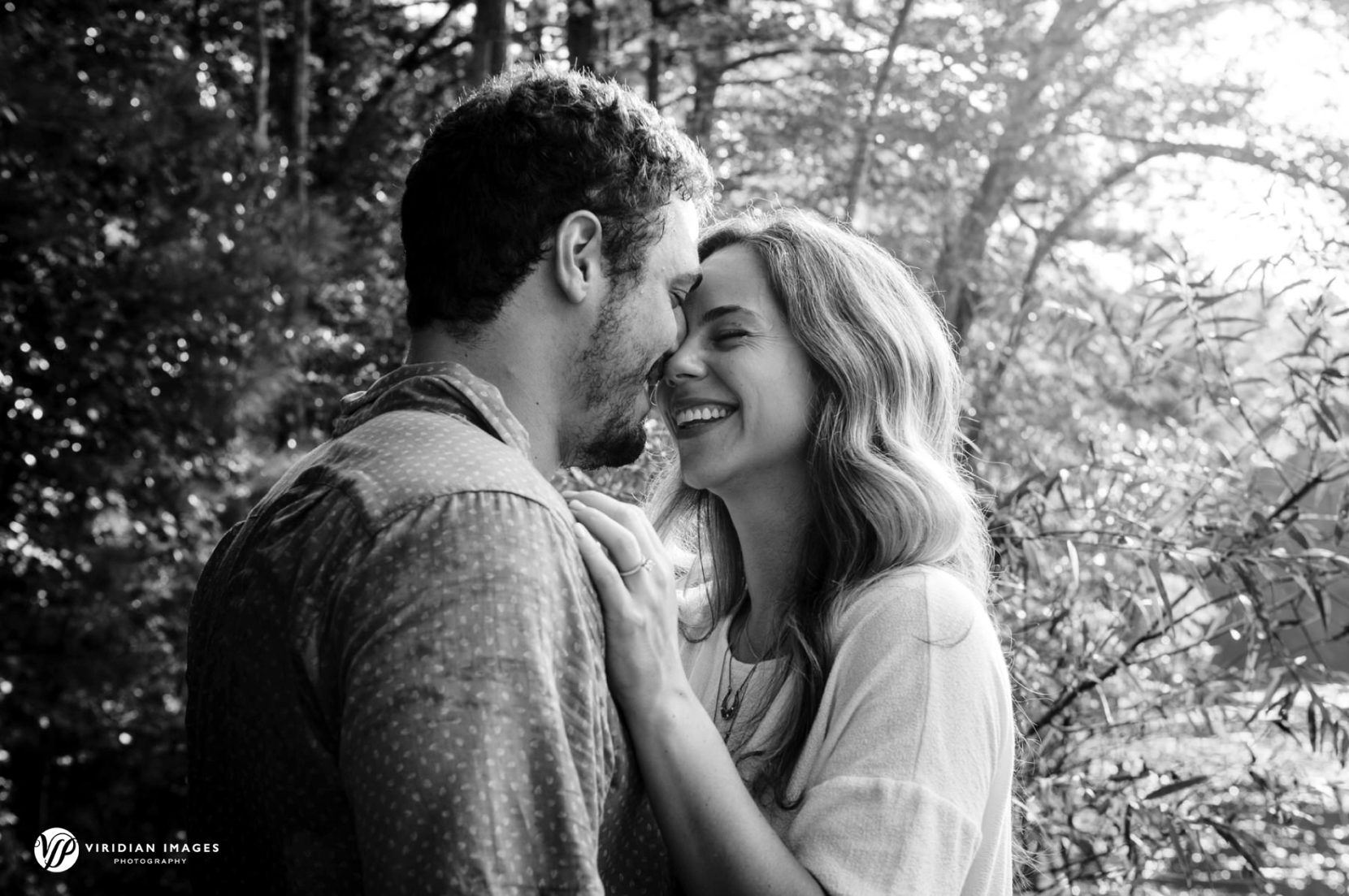 romantic couple smiling during engagement session at Sope Creek