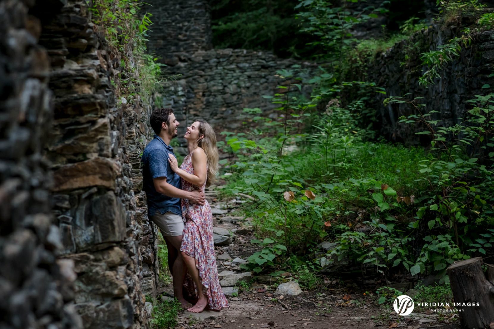 Engaged couple laughing and sharing a candid moment inside the stone ruins along Sope Creek