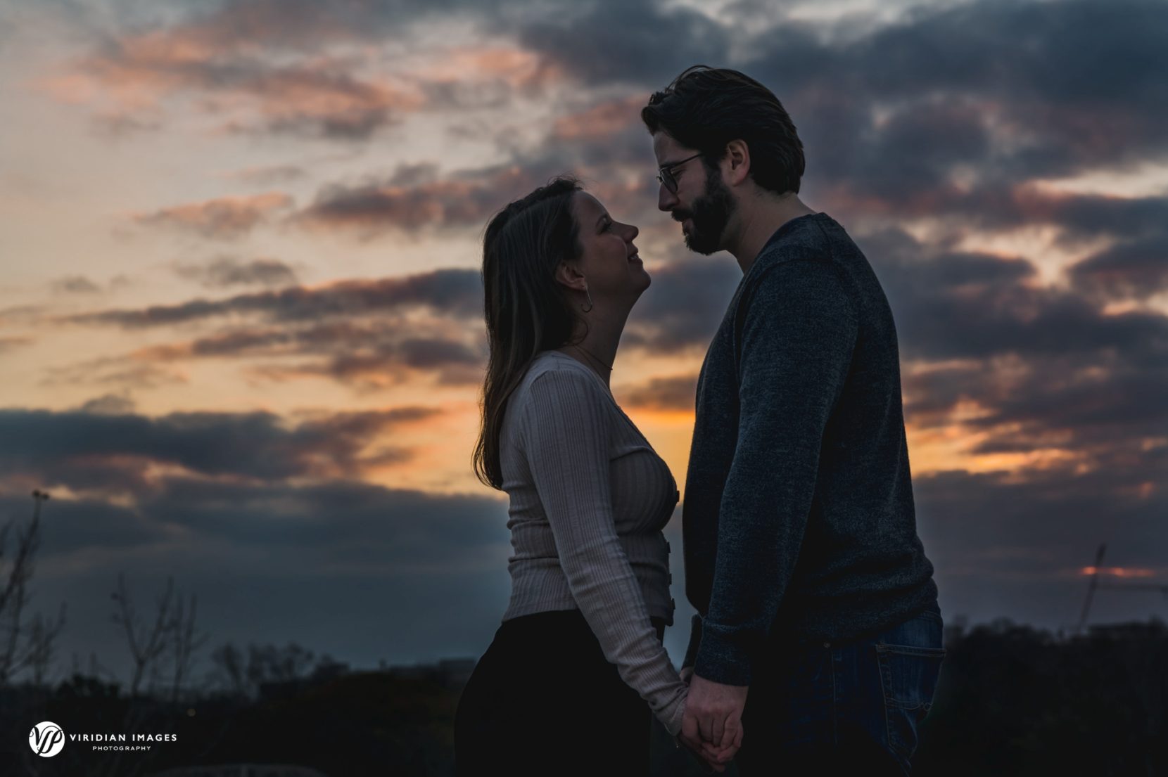 Engaged couple facing each other against beautiful sunset in Atlanta