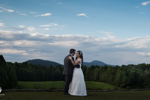 Bride and groom hugging with sweeping mountain views at Meadows at Mossy Creek
