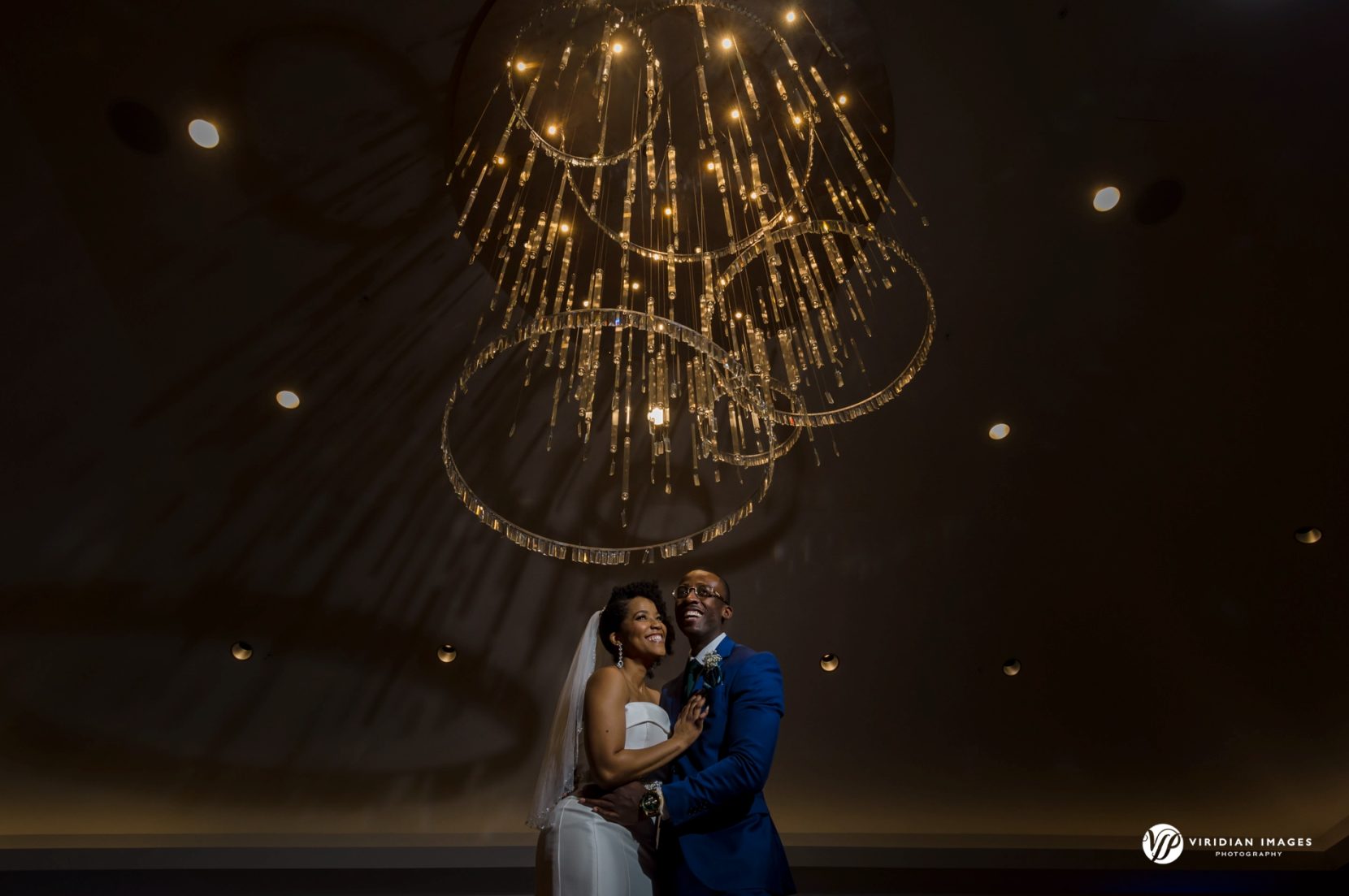 Bride and groom embrace in elegant indoor space at Villa Christina on a rainy wedding day