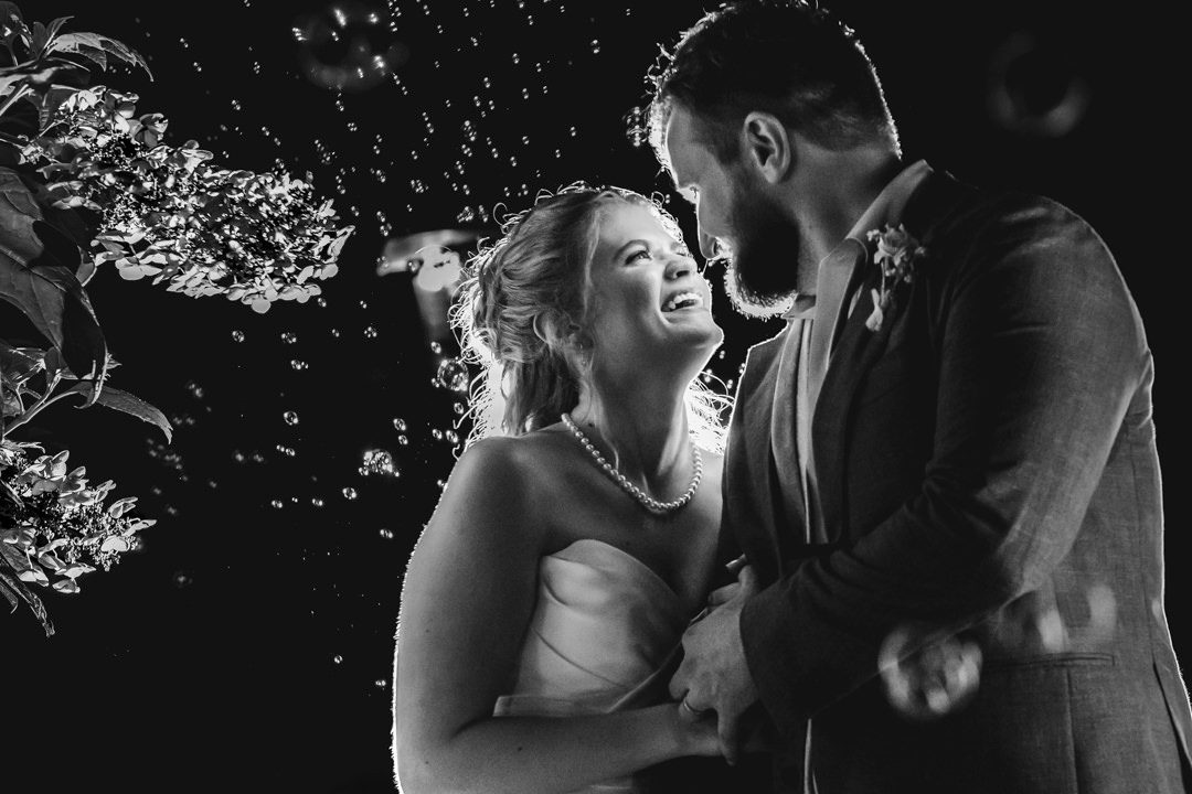 Happy bride looks at groom right before walking towards their bubble exit at Dunwoody Nature Center timeless wedding photography