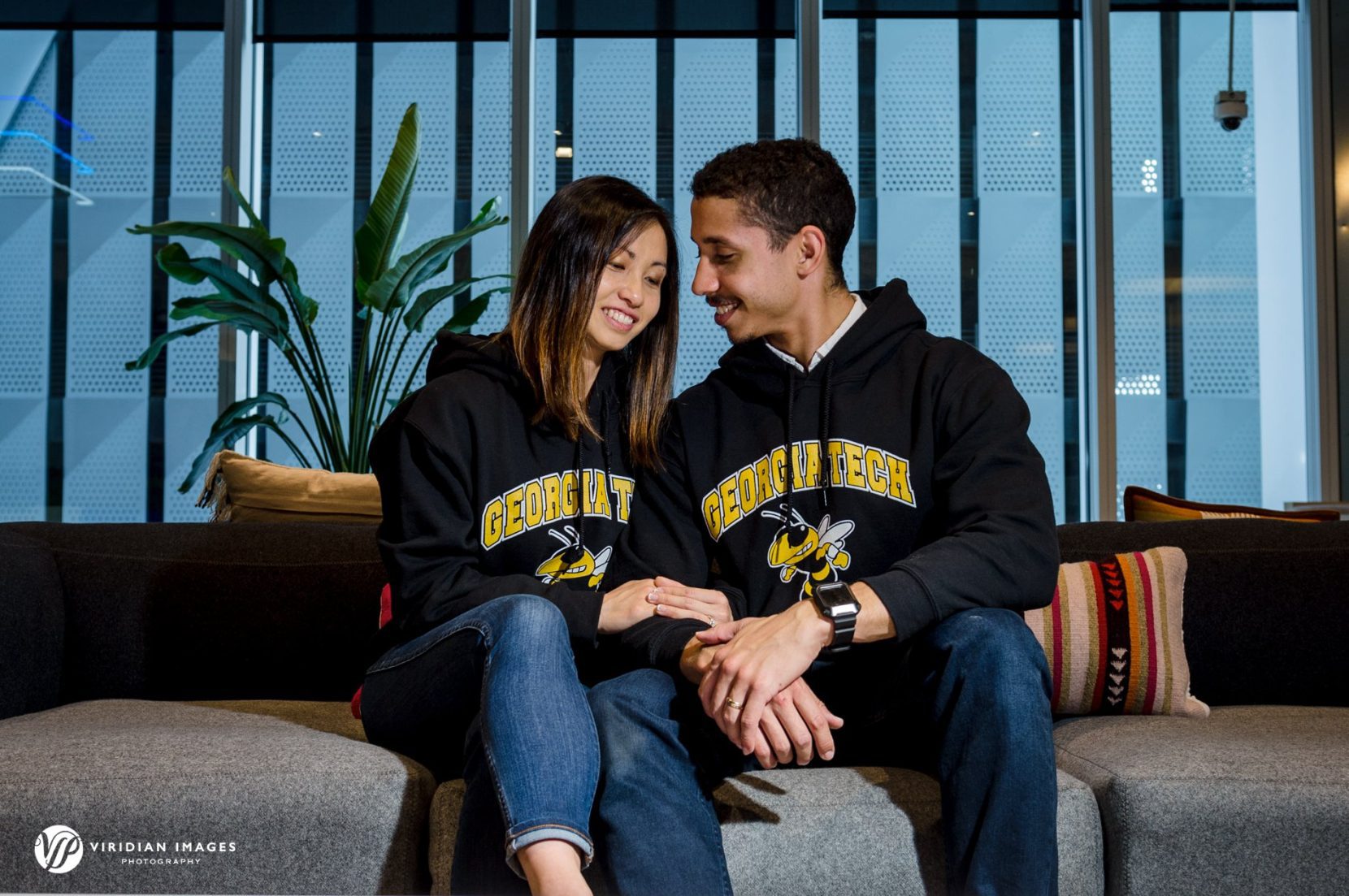 Emily and Robert sit on couch of Georgia Tech's break room at during engagement session