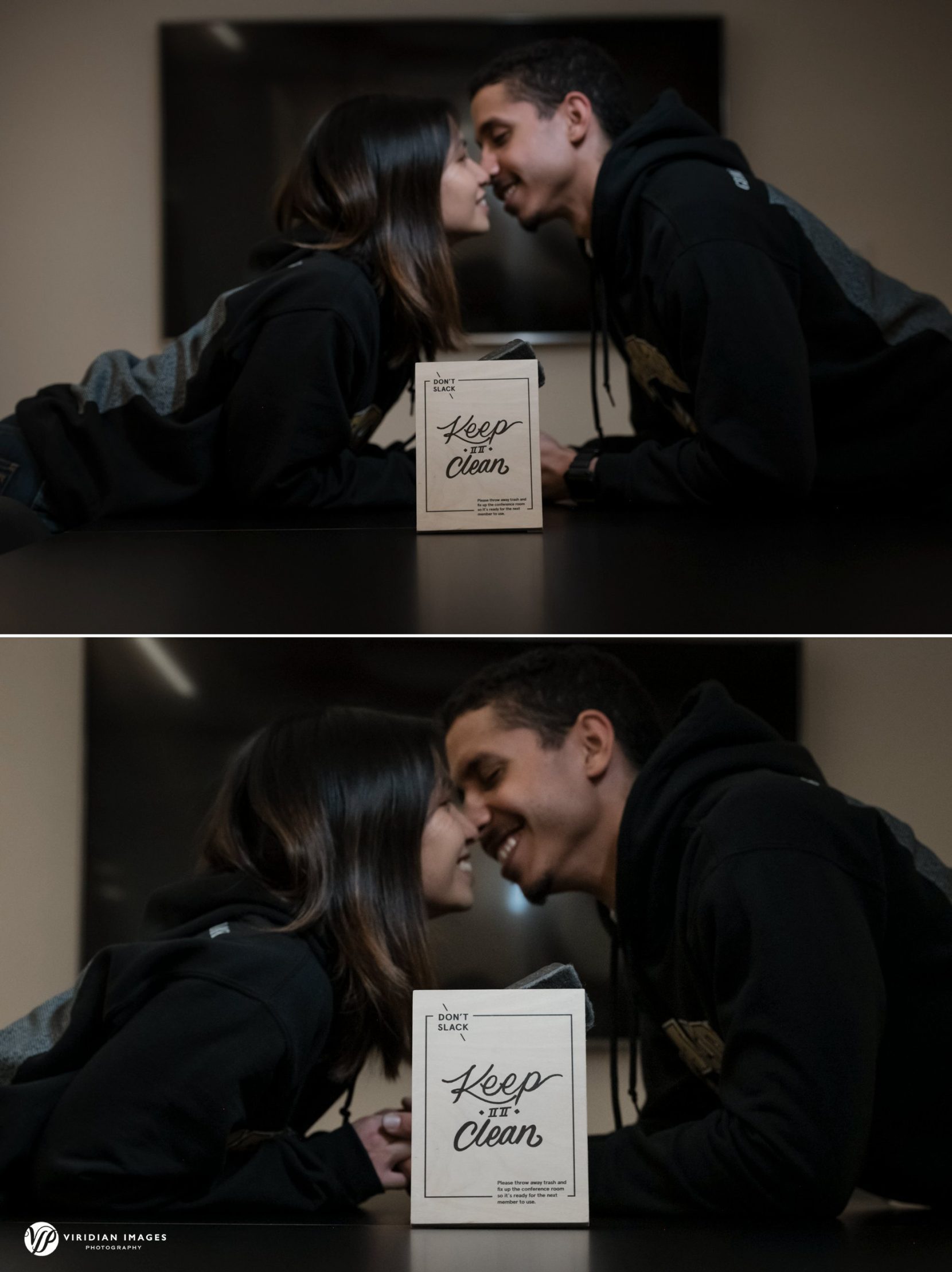 Engaged couple kissing across conference room table during engagement session at Georgia Tech