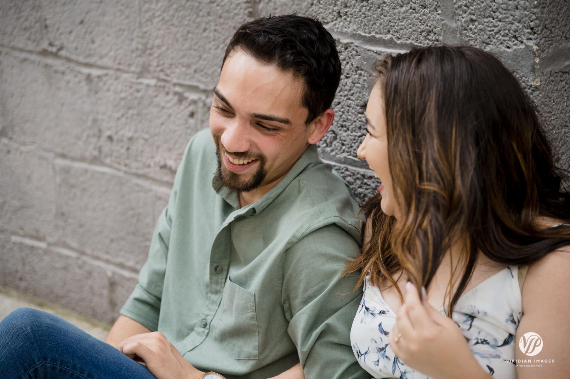 Bride-to-be and groom-to-be laughing together during engagement session at Piedmont Park
