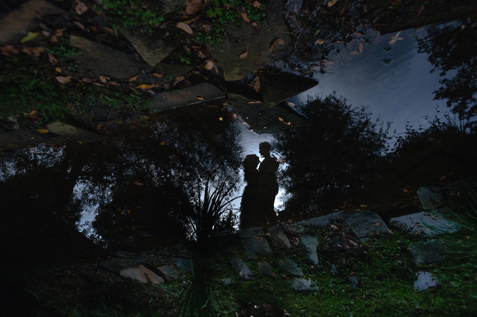 reflection of silhouette of engaged couple with ripple during fall engagement session at Inman Park Atlanta
