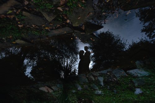 reflection of silhouette of engaged couple with ripple during fall engagement session at Inman Park Atlanta