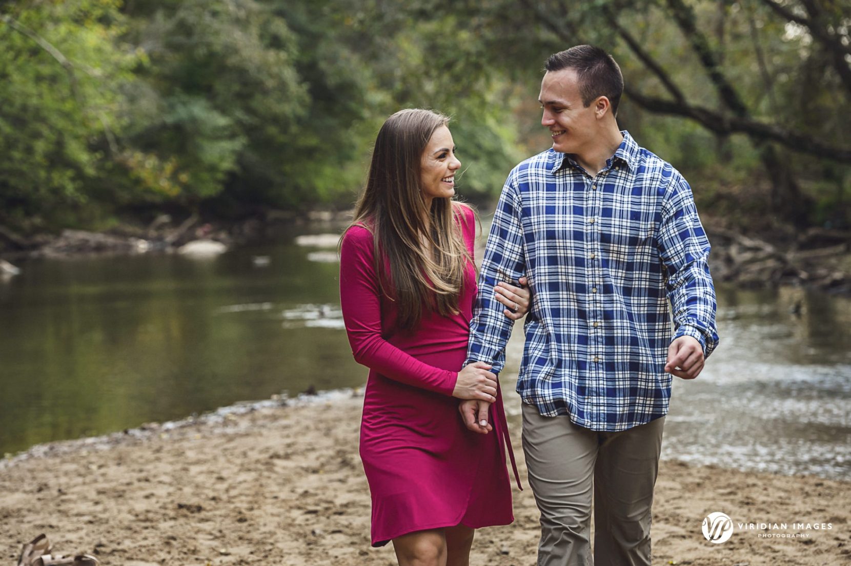 Romantic couple walking on the riverbank during fall engagement session in Atlanta.