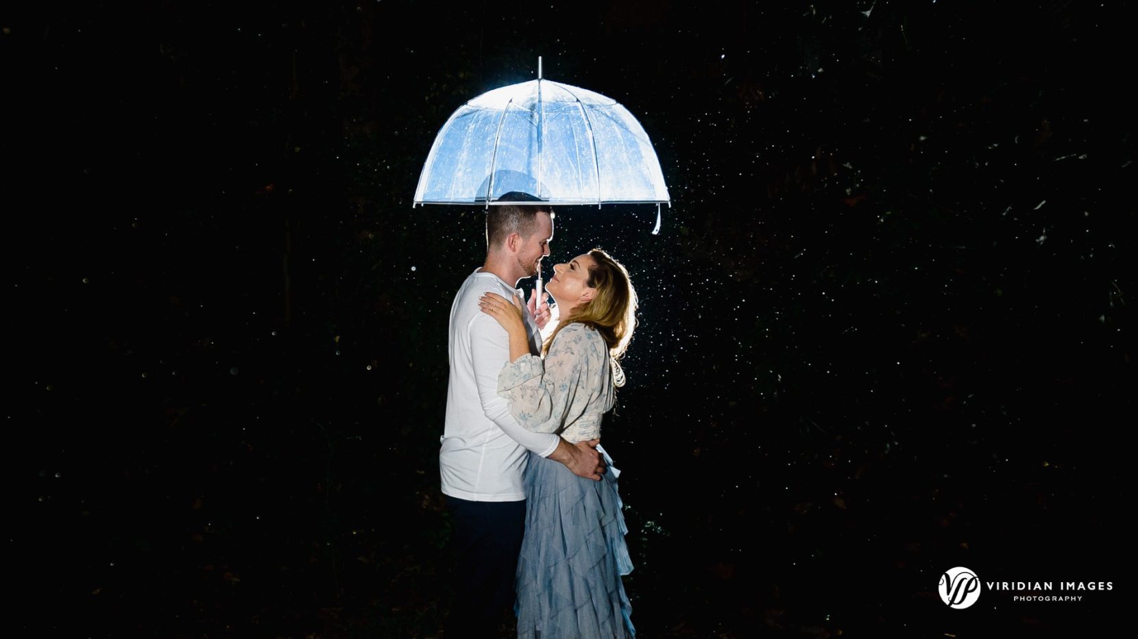couple under clear umbrella while raining during Atlanta engagement session