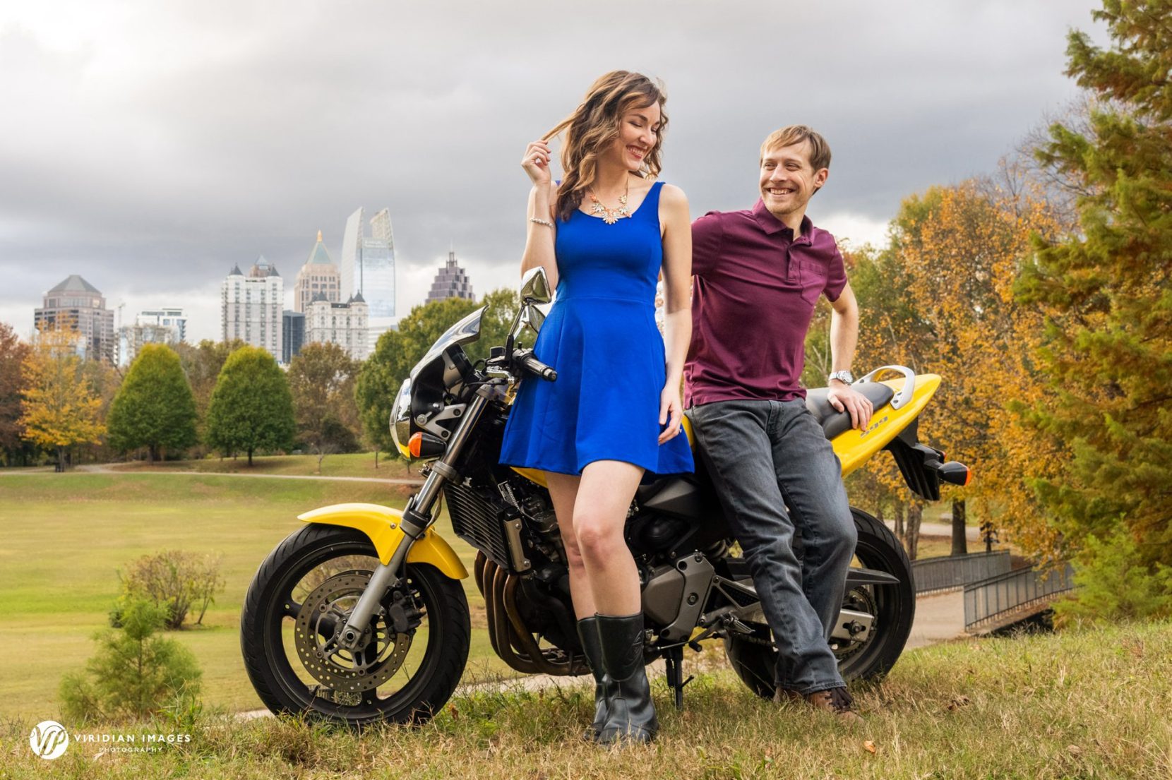 James standing next to his yellow motorcycle while Jenny flirting with him during their session.