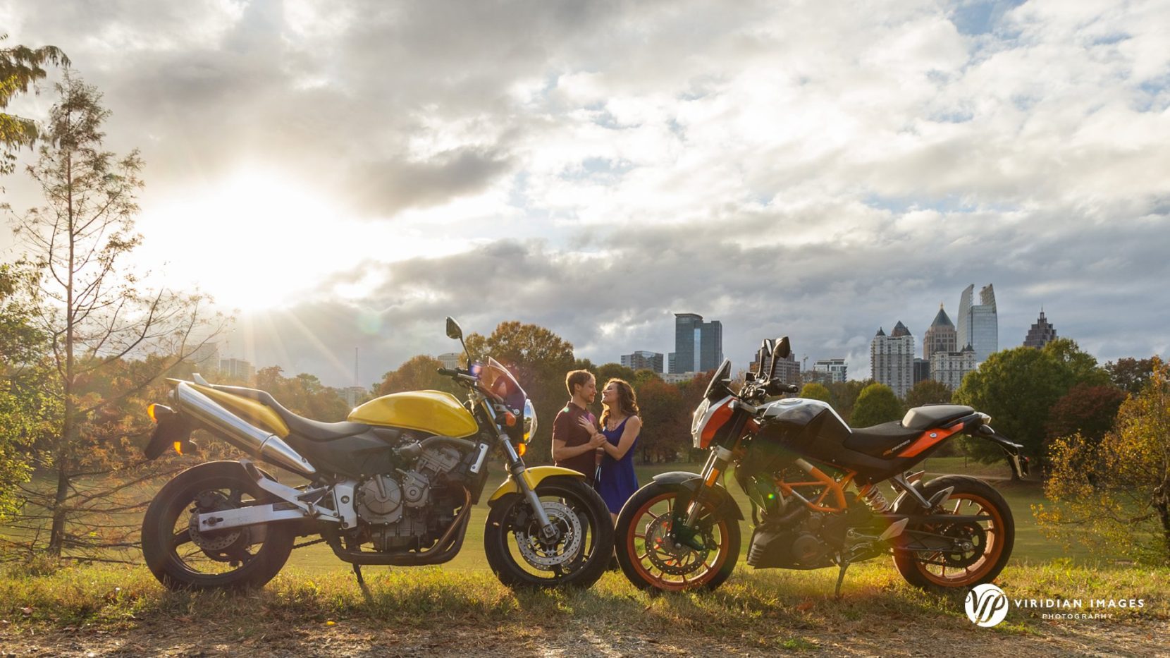 Golden hour sunlight breaking through the clouds while Jenny and James walk through Piedmont Park.
